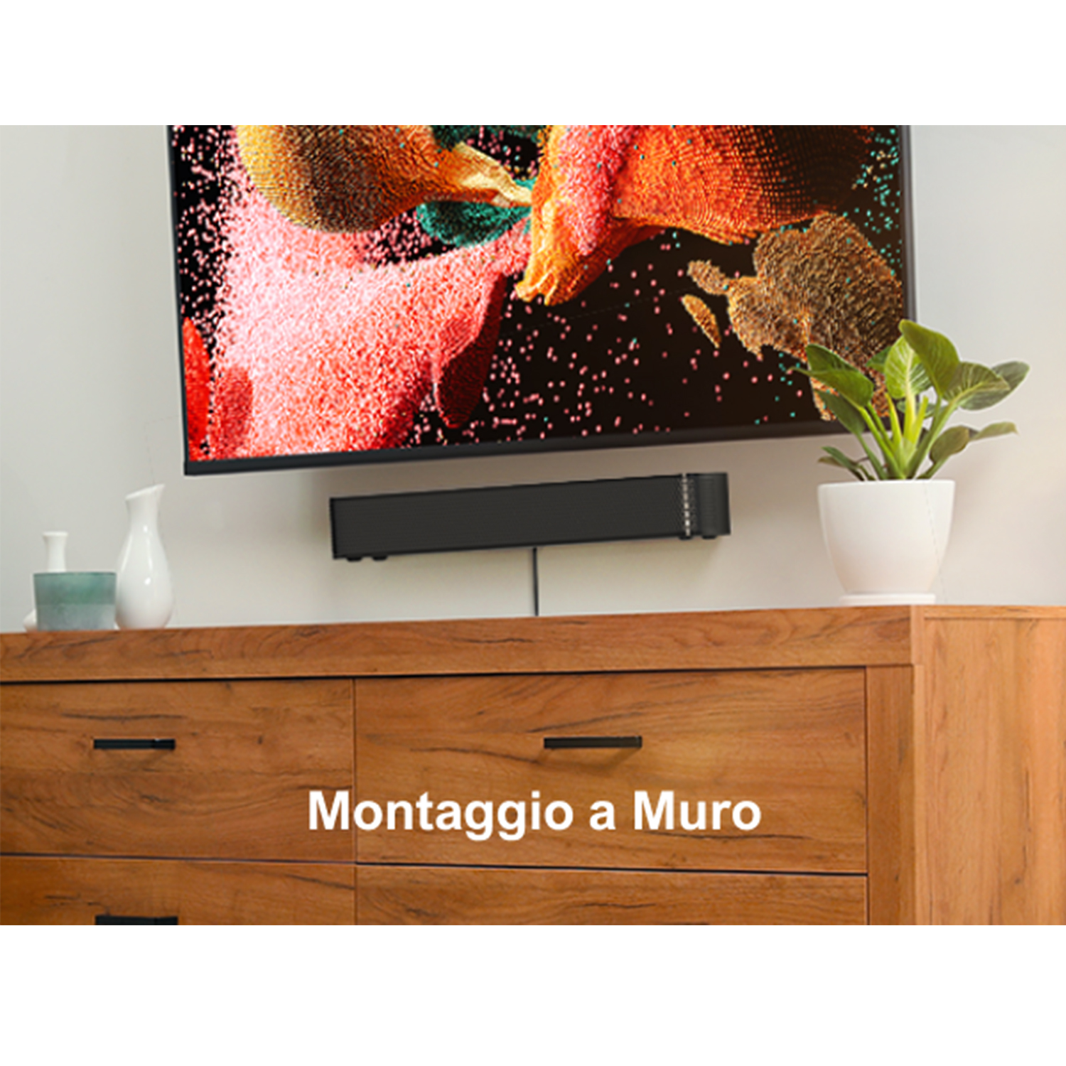 Una TV sul muro, sopra una soundbar e un mobile in legno con una pianta.