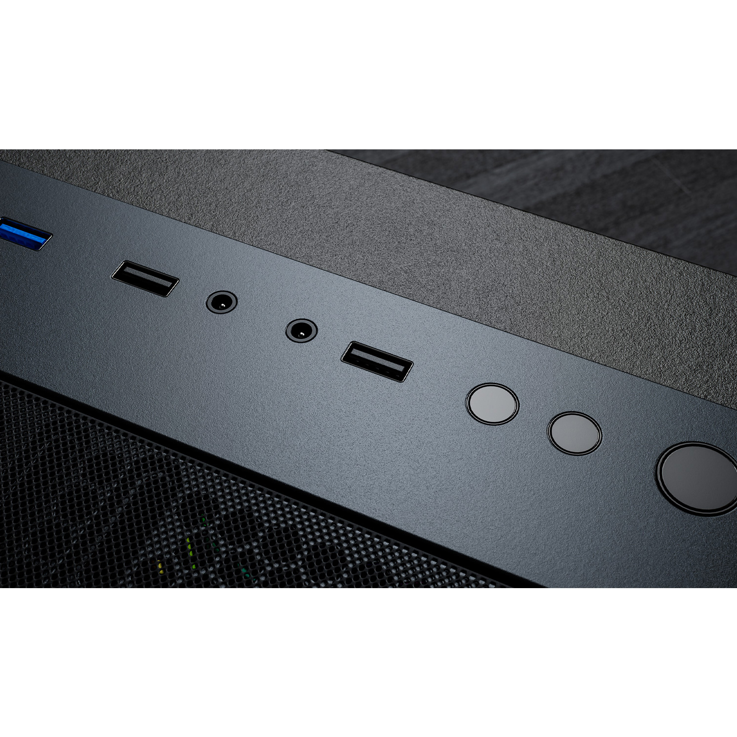 Nahaufnahme der Oberseite eines schwarzen Computergehäuses mit Eingängen, darunter USB- und Audioanschlüsse.