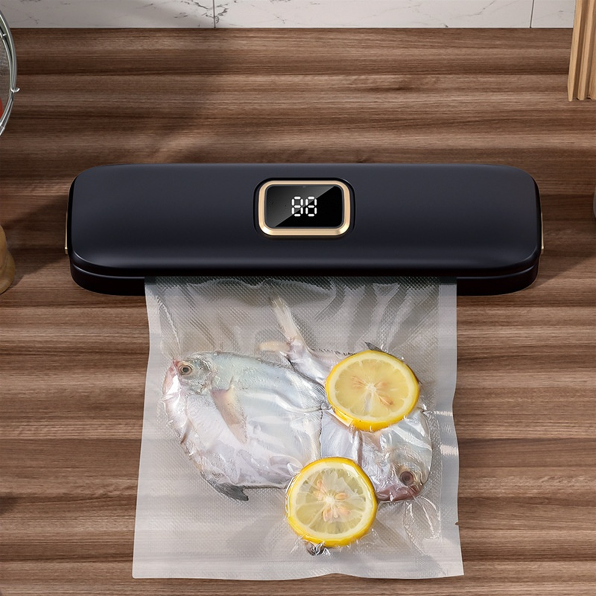 Schwarzer Vakuumierer mit Fisch und Zitronenscheiben in einer transparenten Plastiktüte.