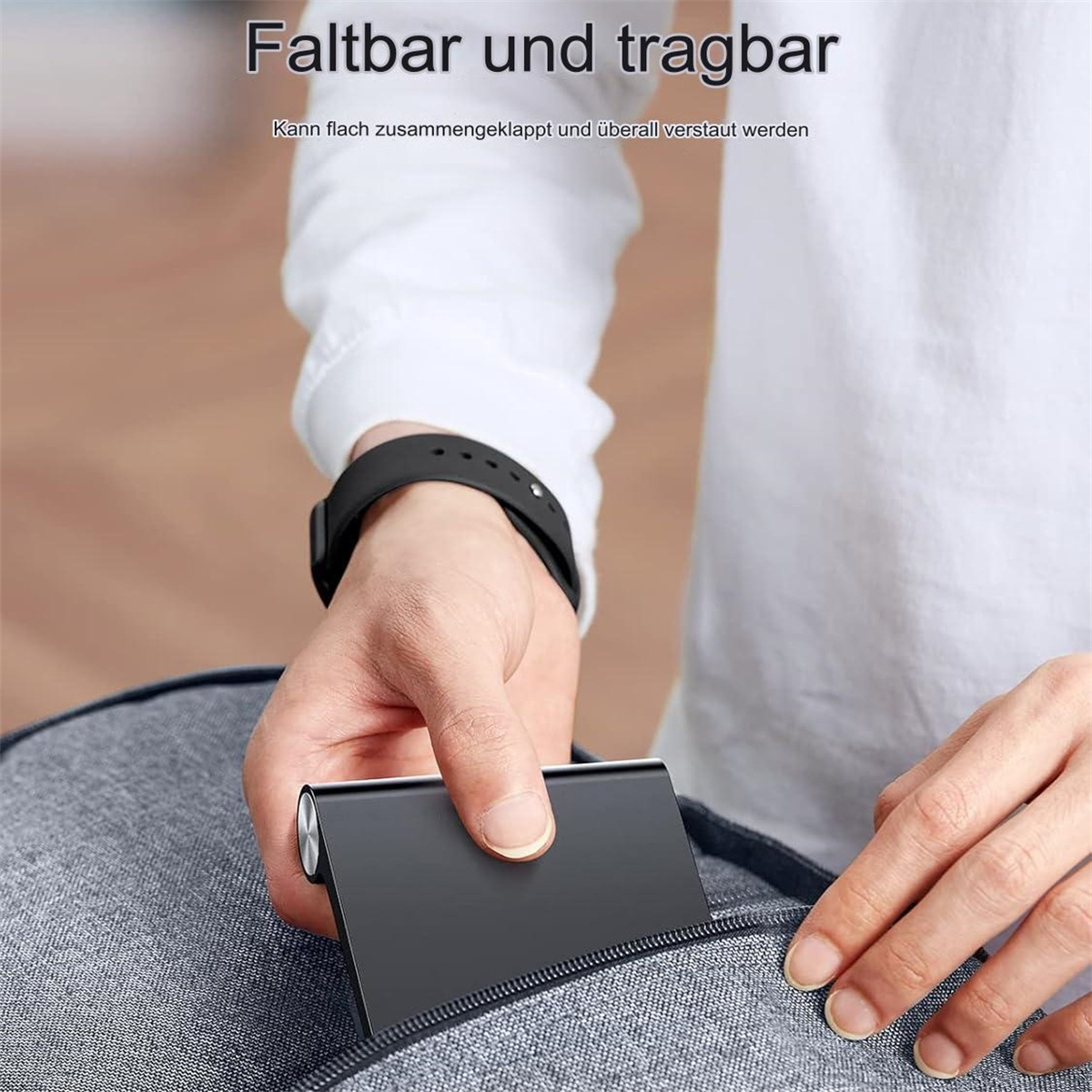 Ein schwarzes, faltbares Gerät wird in eine graue Tasche gelegt. Das Gerät ist rechteckig.