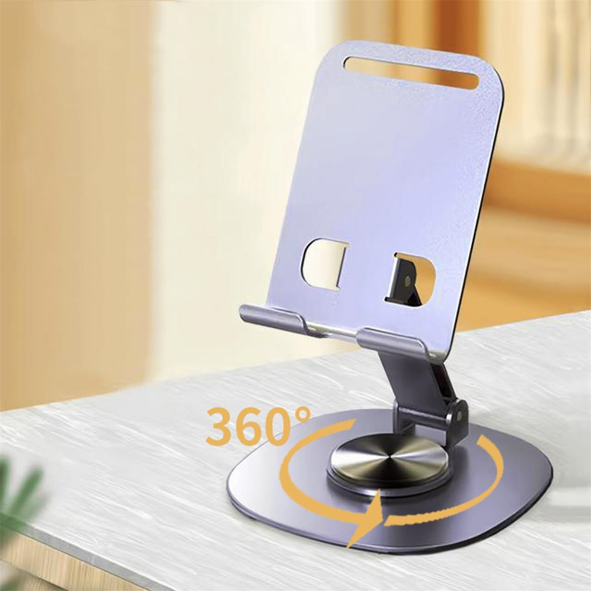Ein silberner Telefonständer steht auf einer weißen Oberfläche. Er hat einen kreisförmigen Fuß und eine 360-Grad-Drehfunktion.