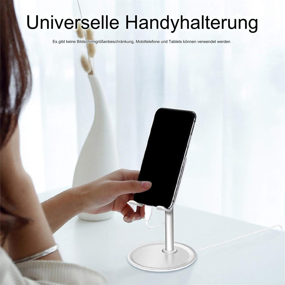 Telefon auf einem Ständer, eine Frau in der Nähe, Text über Handyhalterung oben.