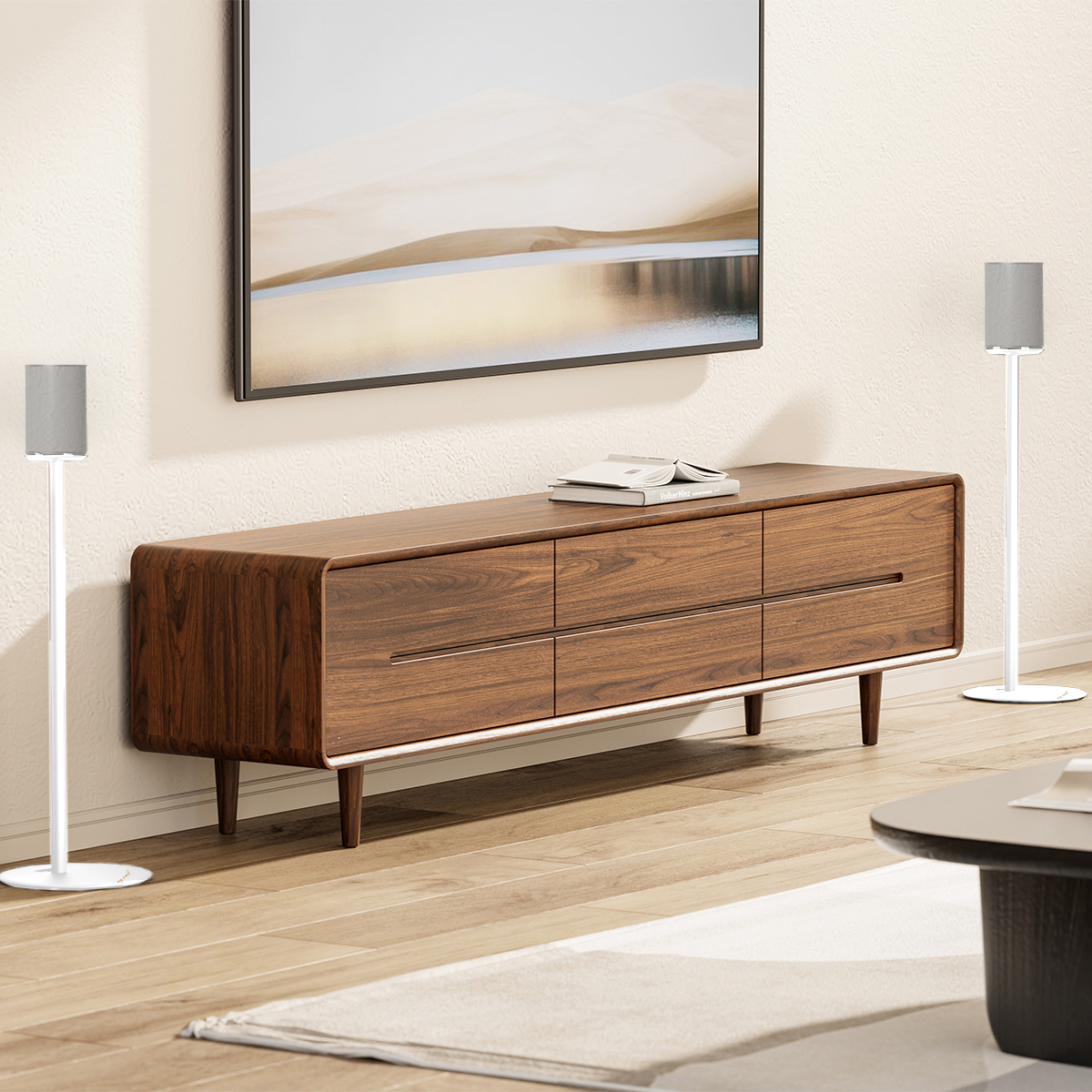 Ein Holz-TV-Ständer mit Schubladen, ein Fernseher darüber, Lautsprecher auf Ständern und ein hellfarbiger Boden.