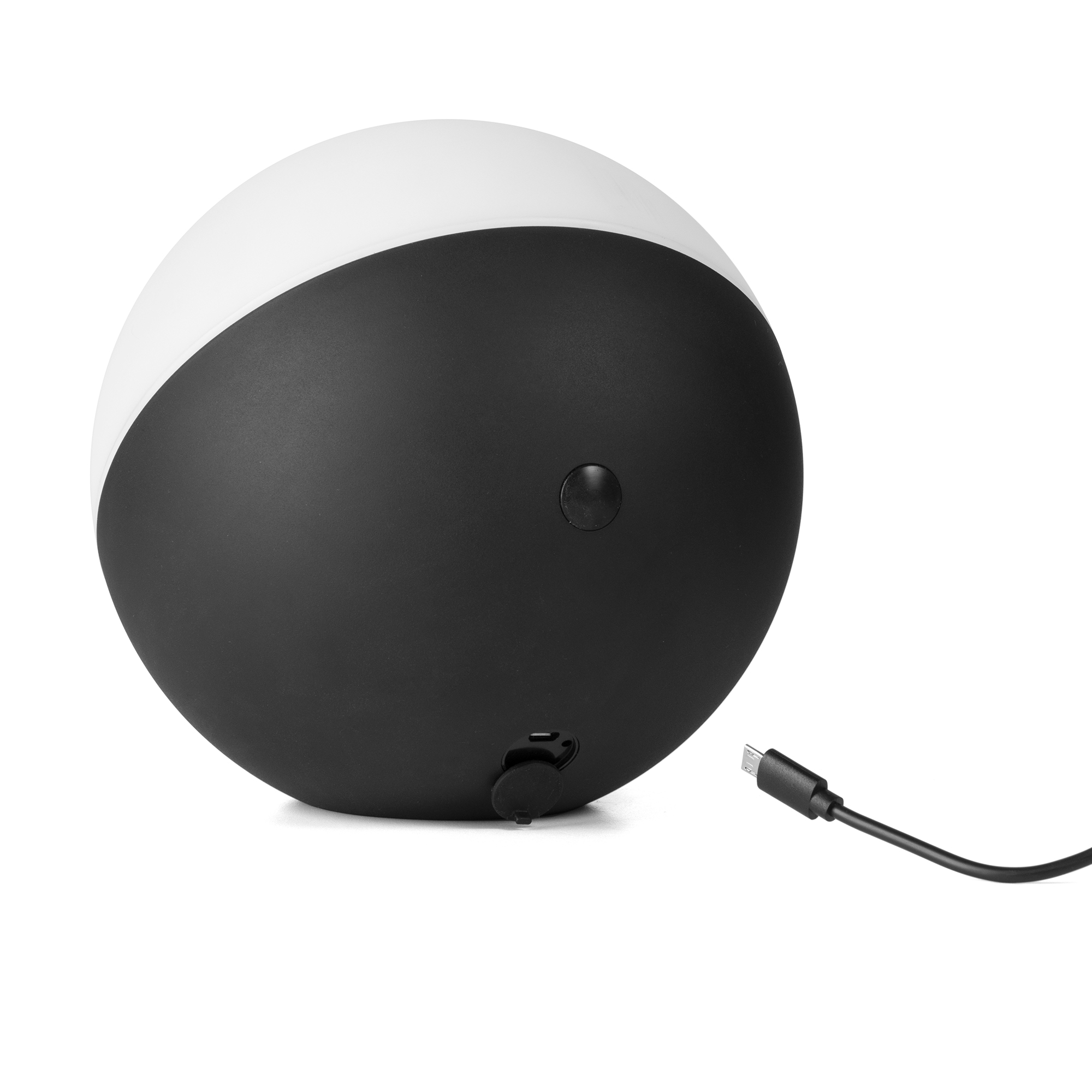 Una lámpara redonda en blanco y negro. Un cable de carga está enchufado a la lámpara.