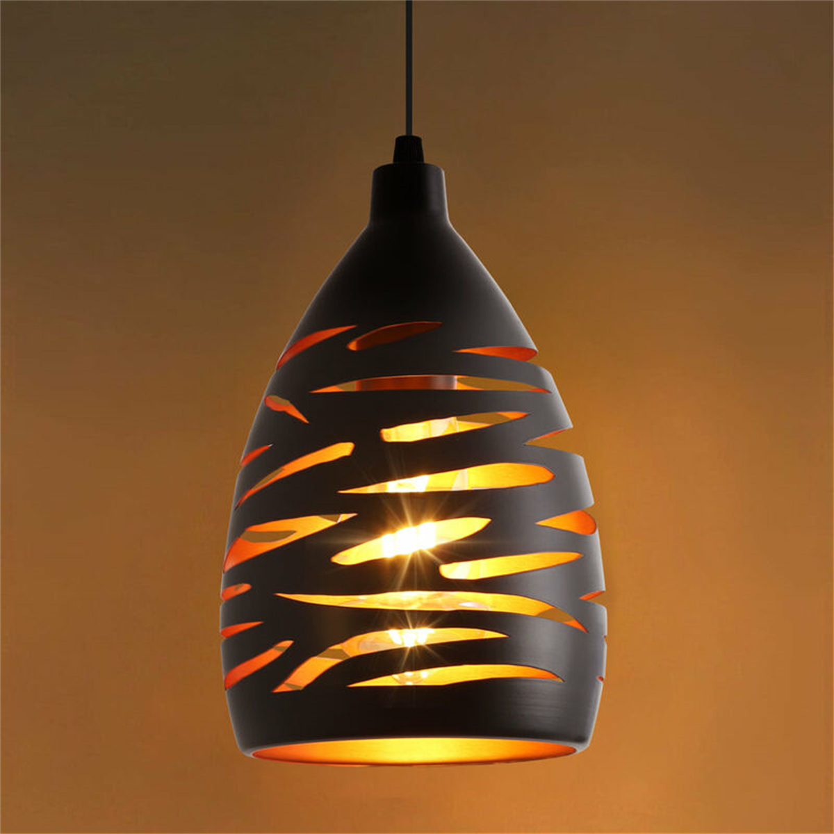 Schwarze tropfenförmige Pendelleuchte mit orangefarbenem Licht, das durch Aussparungen scheint.