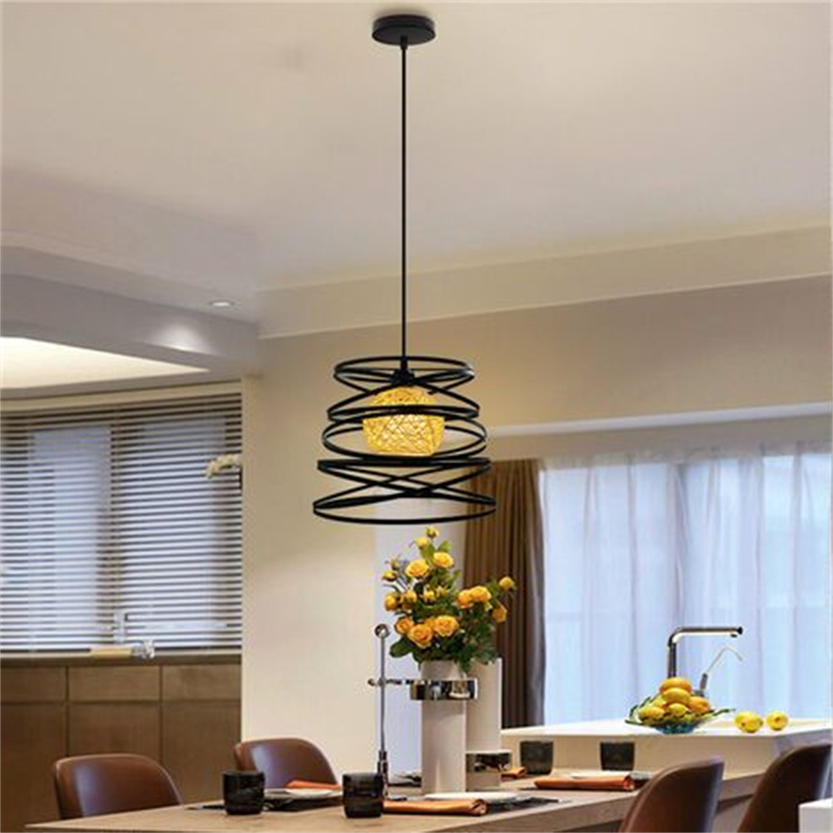 Schwarze Pendelleuchte mit Spiraldesign und gelben Blumen auf dem Tisch.