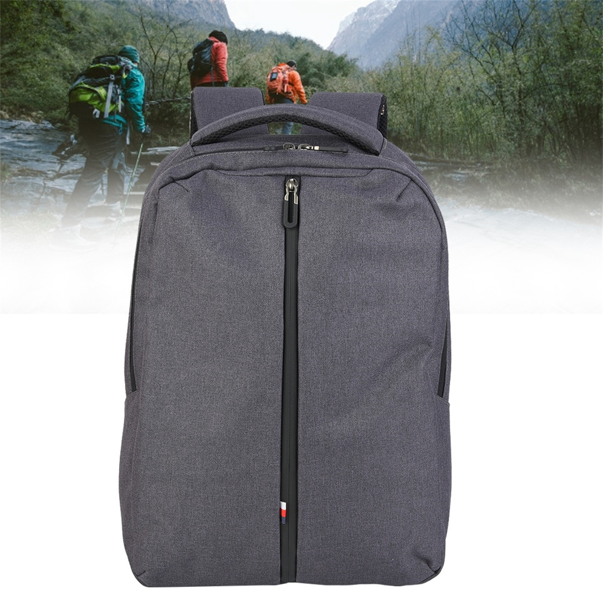 Grauer Rucksack mit schwarzem Reißverschluss und zwei Wanderern im Hintergrund.