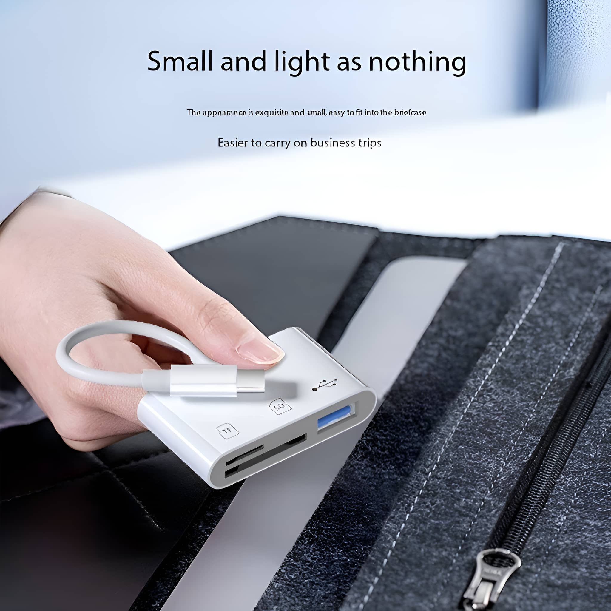 Ein weißer Kartenleser mit einem USB-C-Kabel auf einer dunkelgrauen Oberfläche, neben einem Laptop.