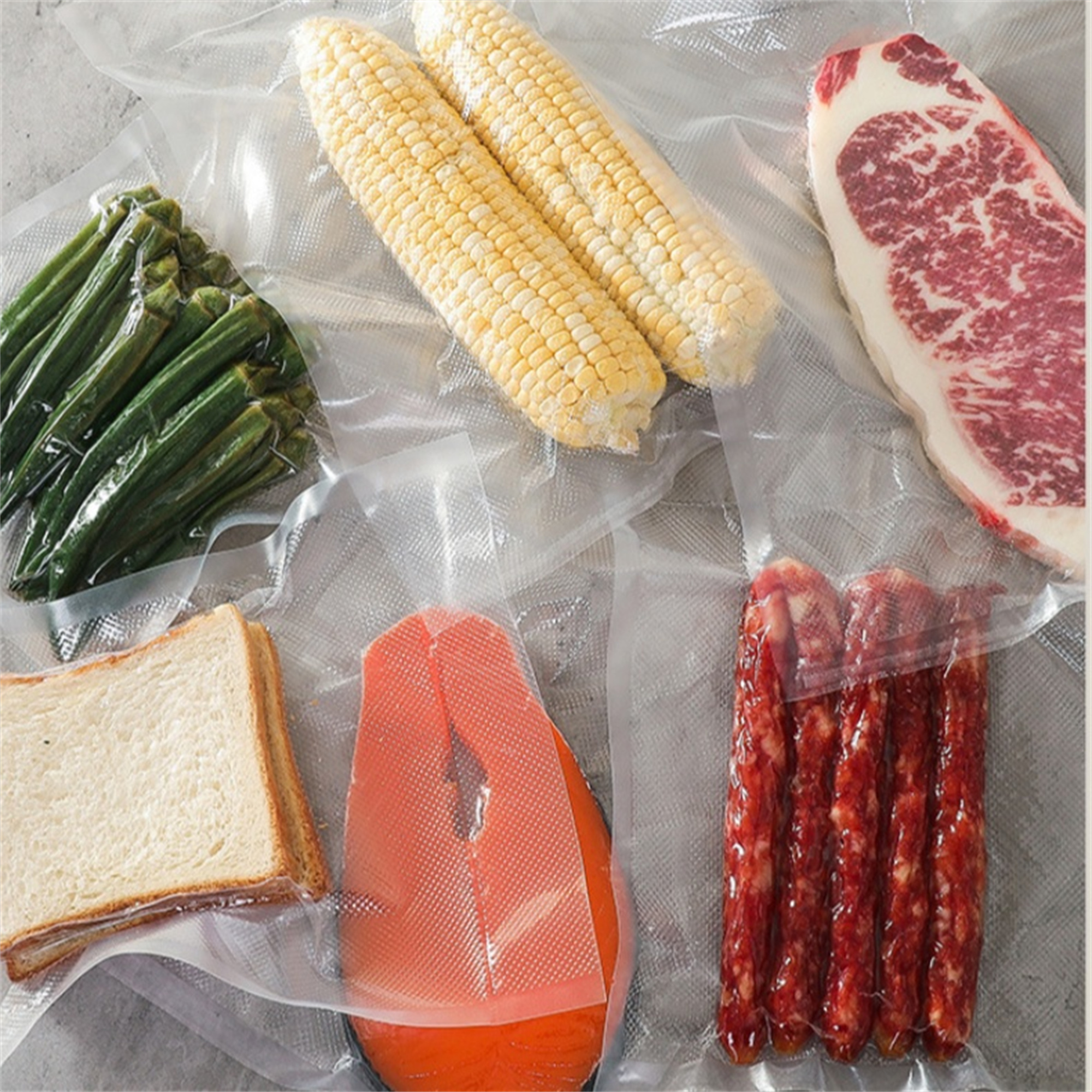 Vakuumversiegelte Beutel mit Lebensmitteln: Mais, Steak, Okra, Brot, Lachs und Würstchen. Draufsicht.