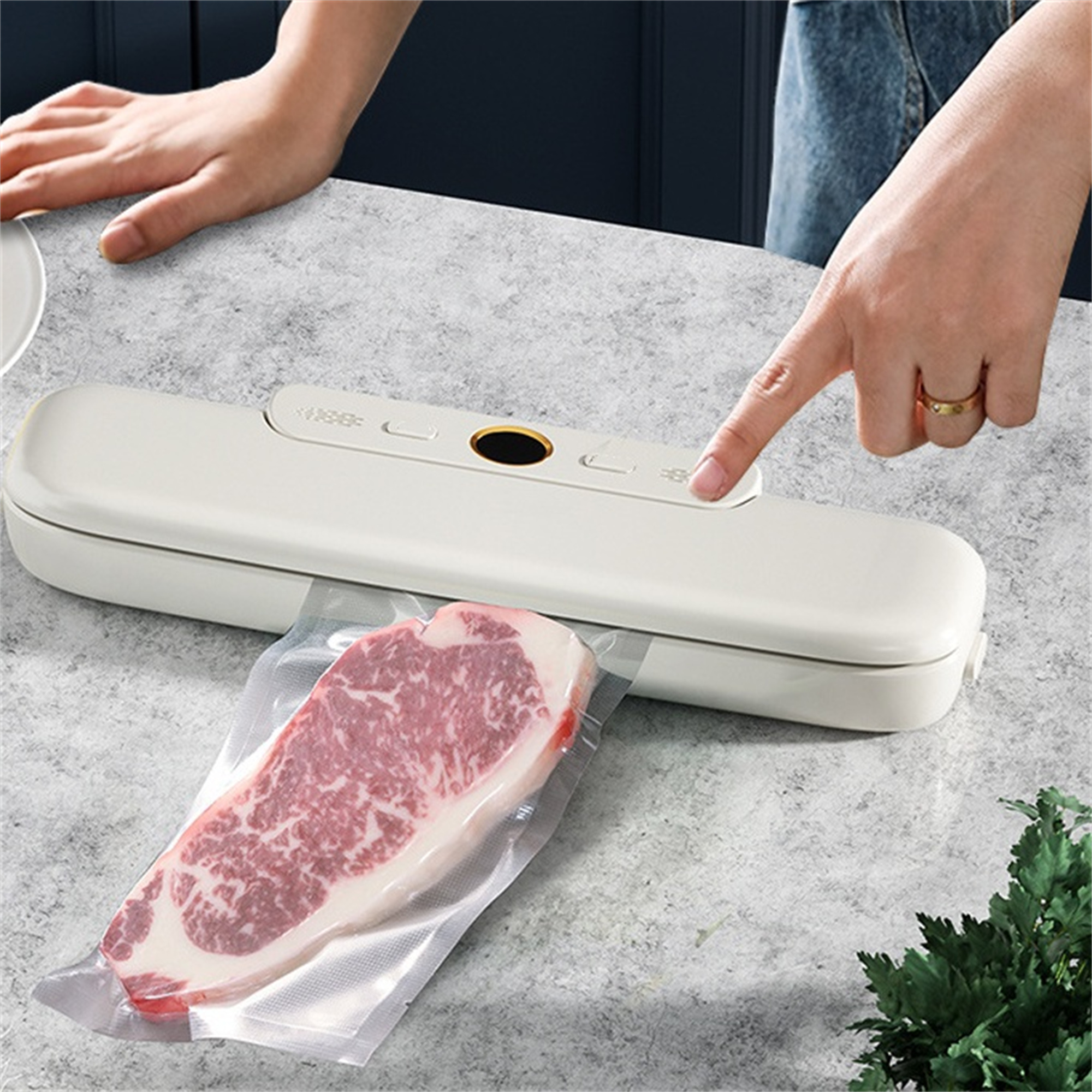 Die Hand einer Frau drückt auf einen Knopf eines Vakuumiergeräts. Ein Steak ist in einem transparenten Plastikbeutel vakuumversiegelt.