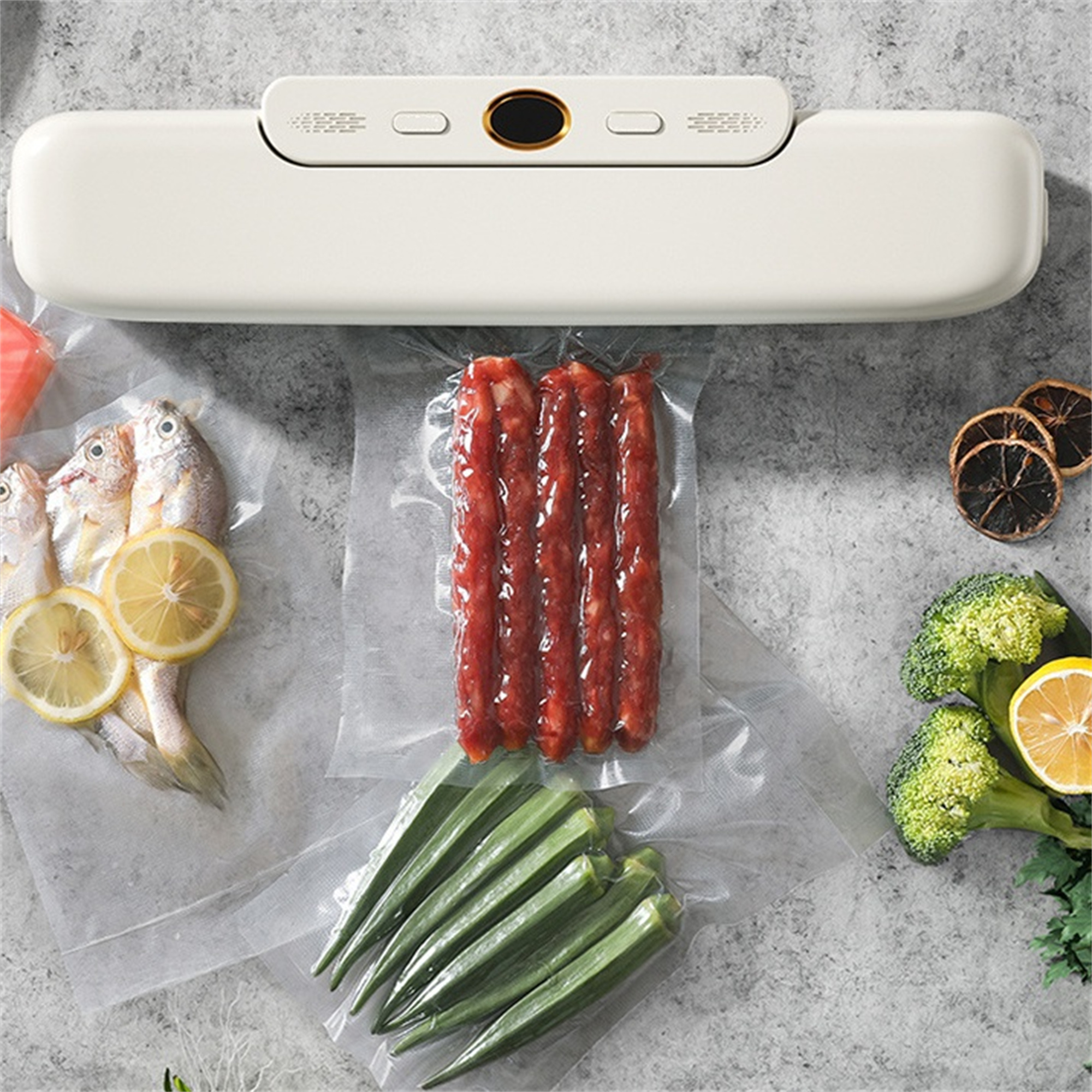 Vakuumiergerät mit verschiedenen Lebensmitteln, darunter Fisch, Wurst, Okra, Brokkoli und Zitronenscheiben.