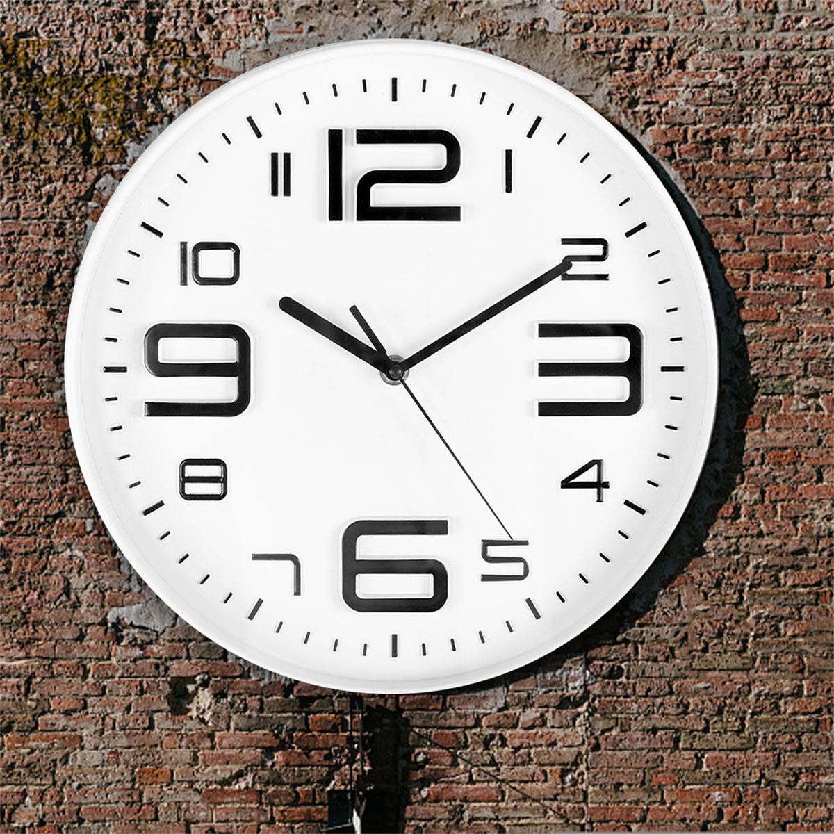 Eine weiße Uhr mit schwarzen Zahlen und Zeigern, an einer roten Backsteinmauer befestigt.