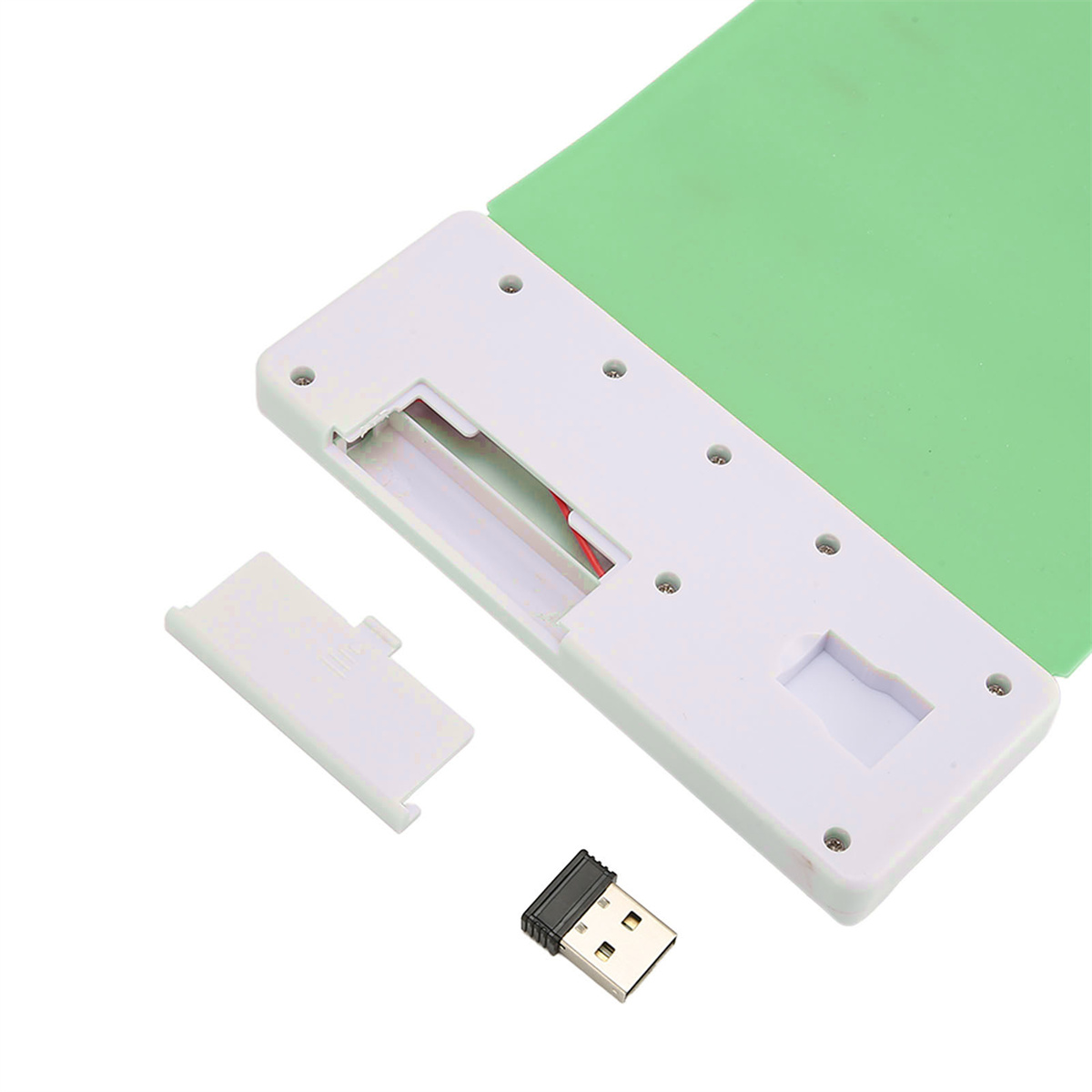 Ein weißes Gerät mit einem grünen Pad, einem USB-Adapter und einer abgenommenen Abdeckung.