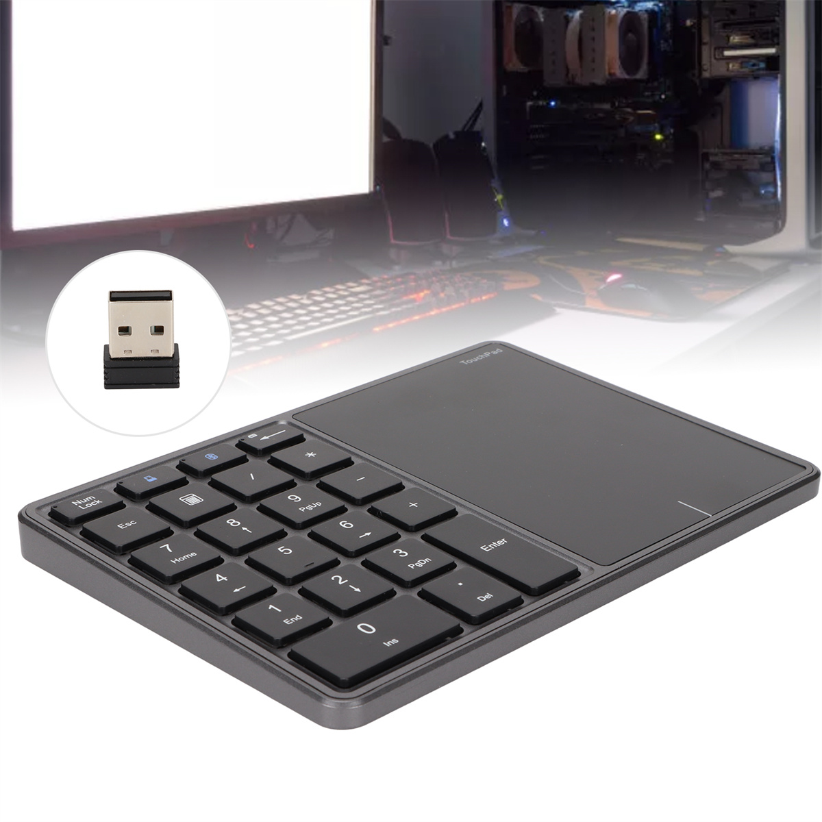 Graues Touchpad mit Nummernblock und USB-Empfänger. Im Hintergrund befinden sich ein Computer und eine Tastatur.