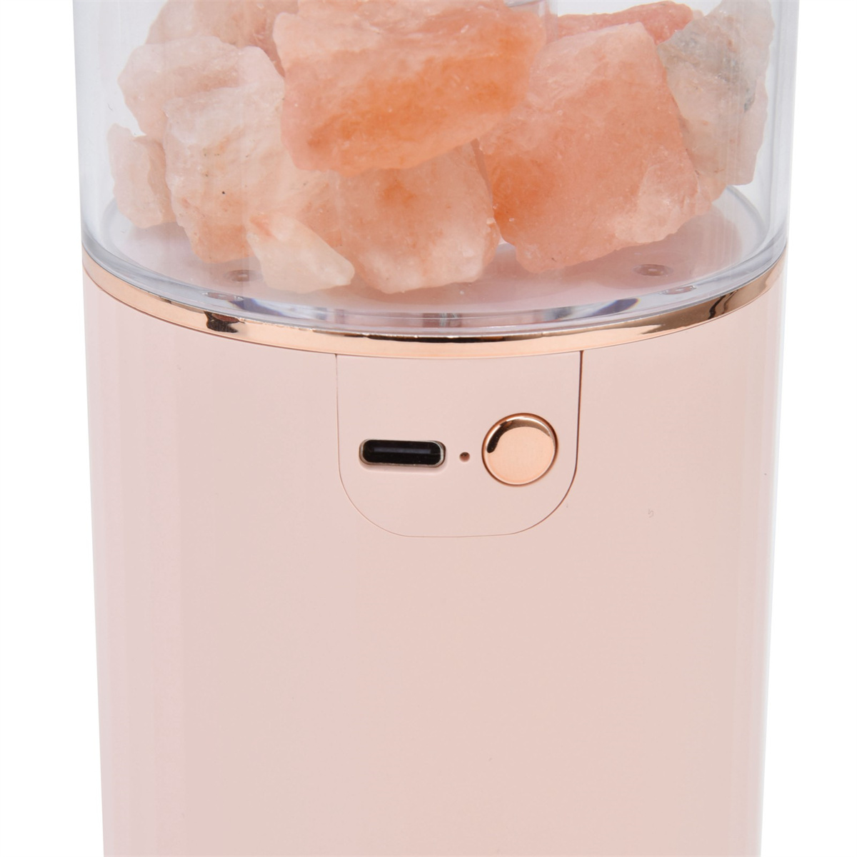 Rosa zylindrisches Gerät mit einem transparenten Deckel, gefüllt mit rosa Salzfelsen. Ein Knopf und ein Anschluss sind sichtbar.