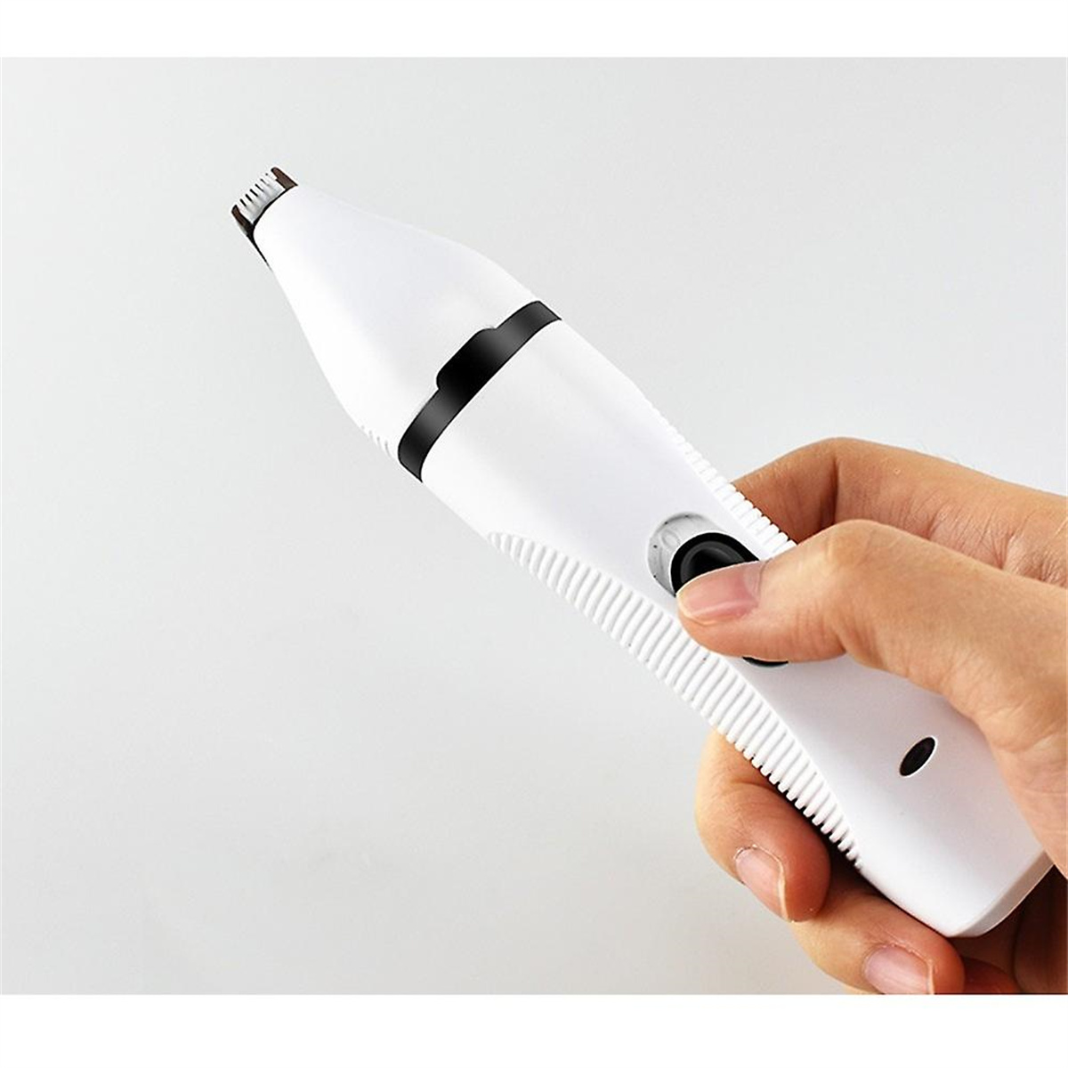 Eine Hand, die einen weißen elektrischen Trimmer mit schwarzem Akzent hält. Ein Knopf wird gedrückt.