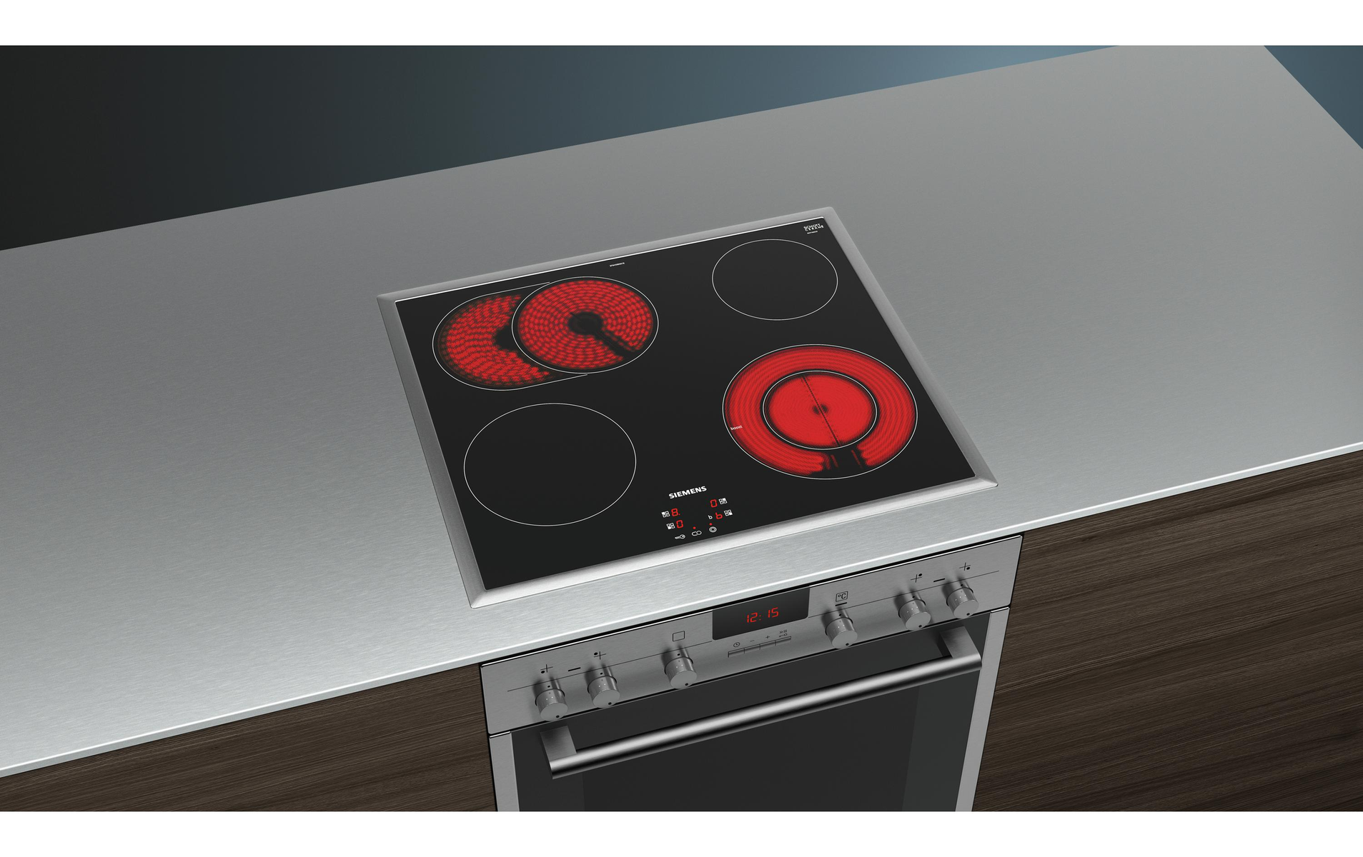 Table de cuisson à induction noire et argentée avec quatre éléments chauffants allumés en rouge. Comptoir en acier inoxydable.
