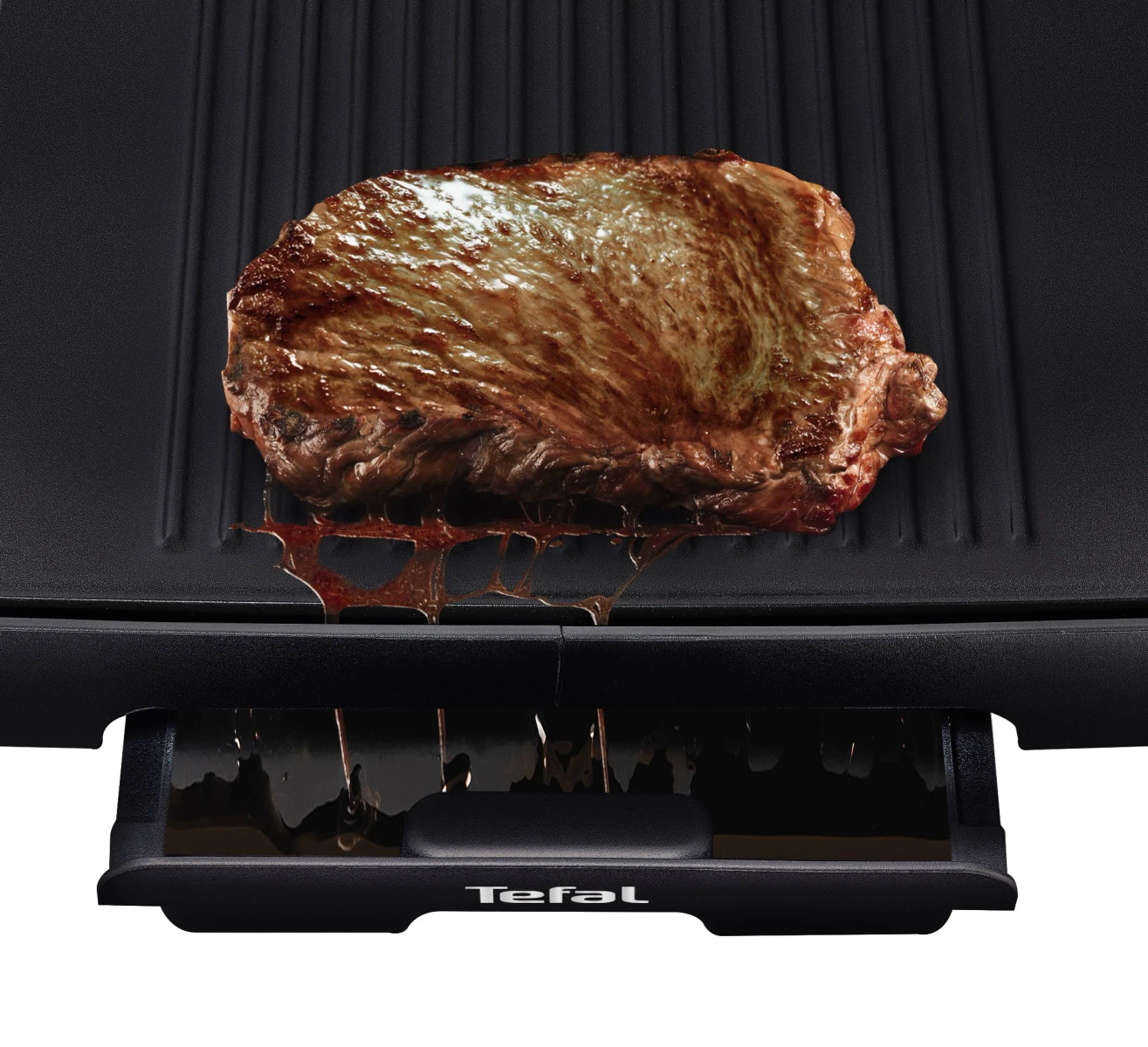 Filete a la parrilla sobre una parrilla negra con bandeja de grasa visible. Toma de cerca.