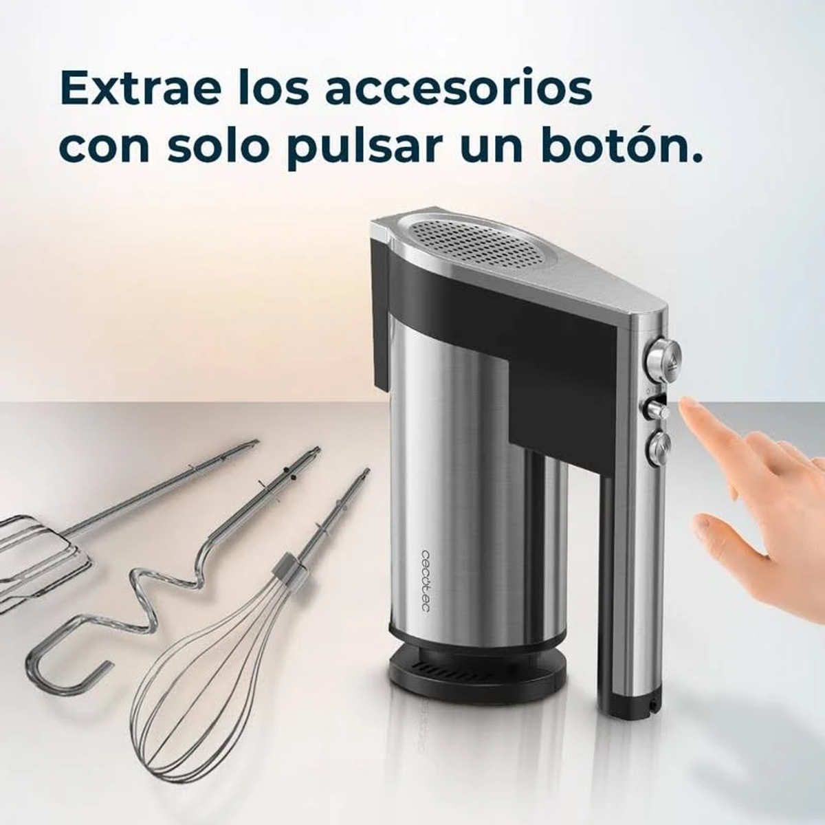 Mano che raggiunge un frullatore a mano argentato con accessori. Testo: "Estrai gli accessori con la semplice pressione di un pulsante."