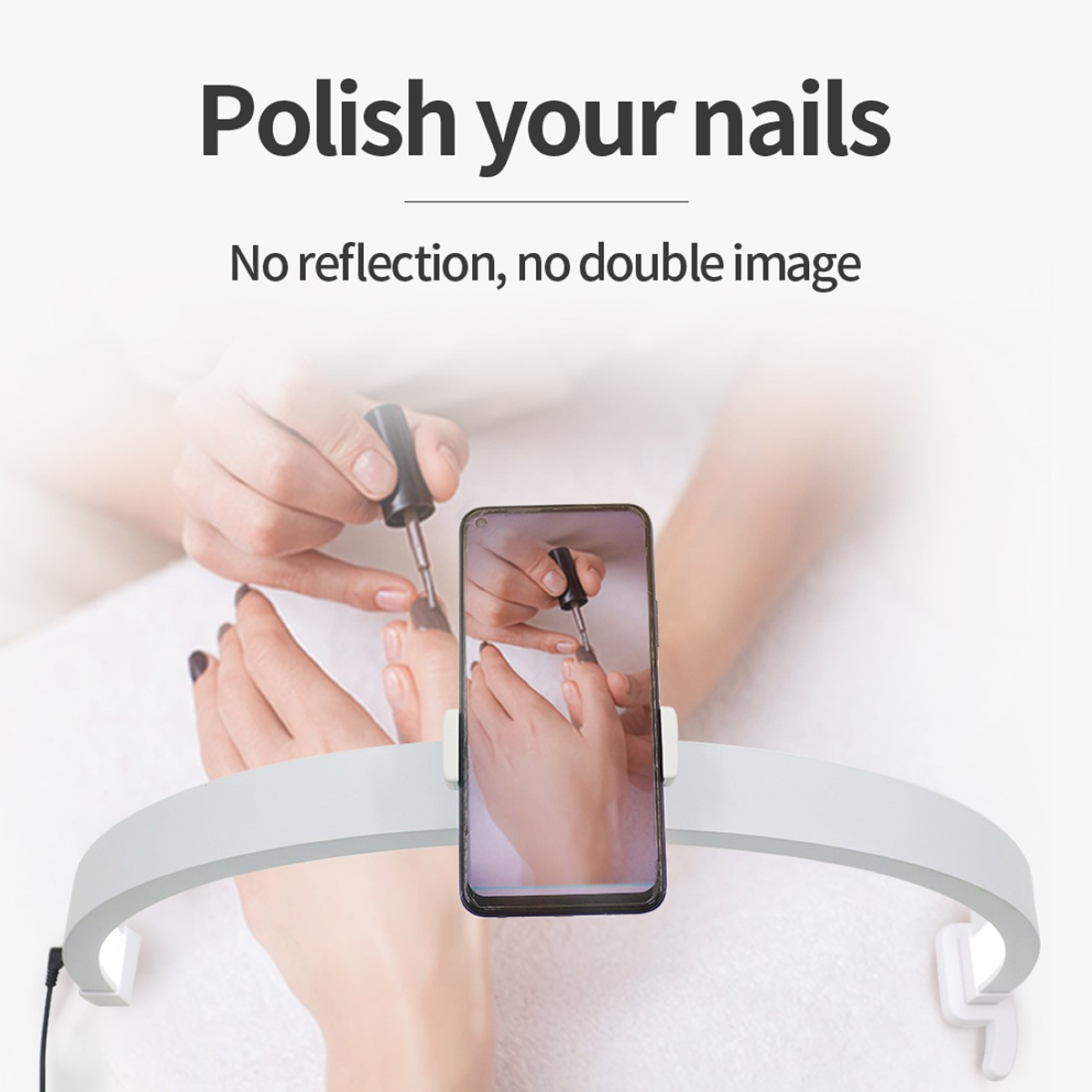 Hände lackieren Nägel, mit einem Telefon vor einer Lampe.