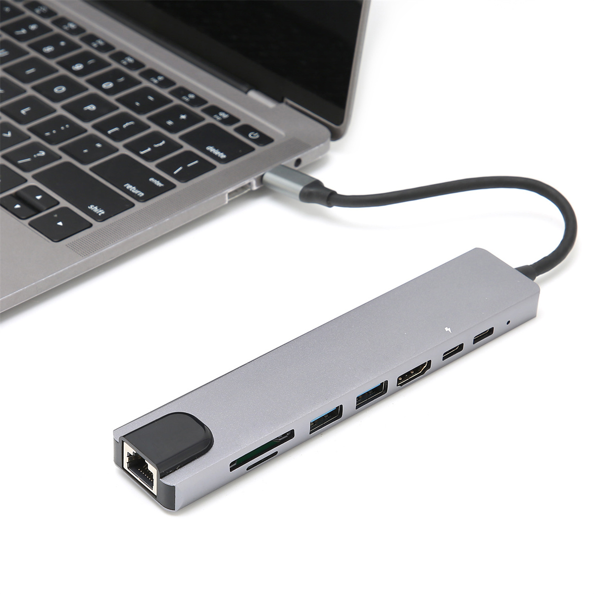 Laptop mit einem grauen Multiport-Adapter verbunden.