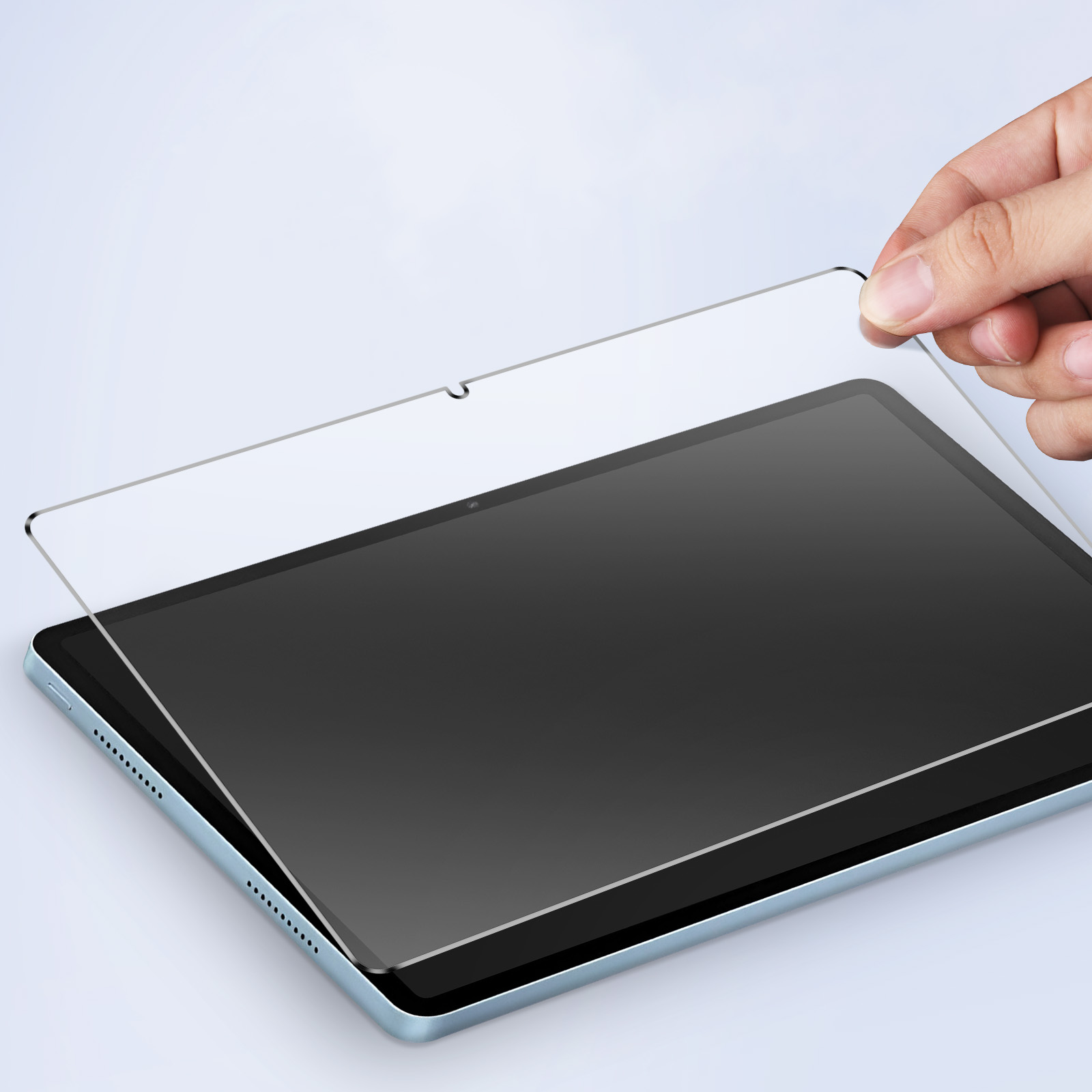 Una mano tiene uno schermo protettivo sopra un tablet nero, pronto per essere applicato.
