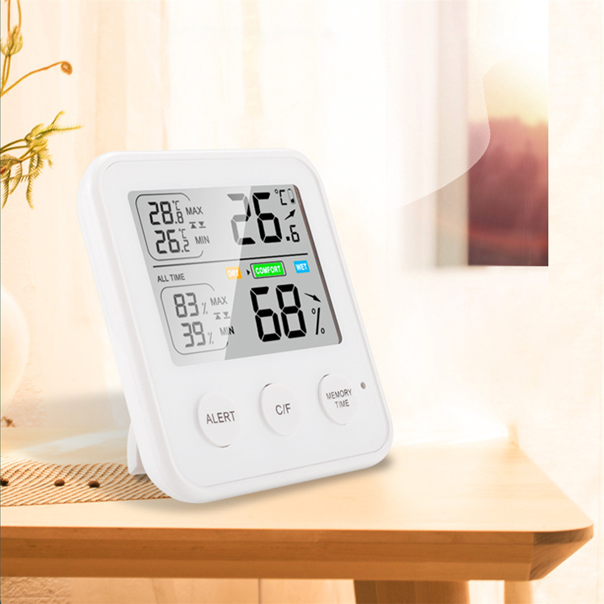 Weißes digitales Thermometer, das Temperatur- und Feuchtigkeitswerte anzeigt. Ein Holztisch im Vordergrund.