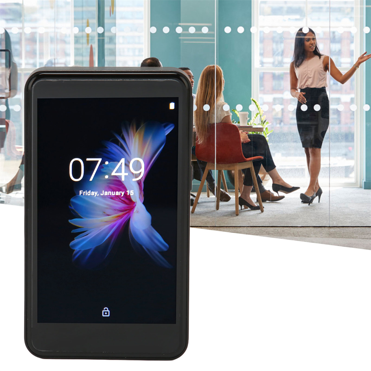 Person hält ein schwarzes Telefon mit Zeitanzeige. Personen sind im Hintergrund zu sehen.
