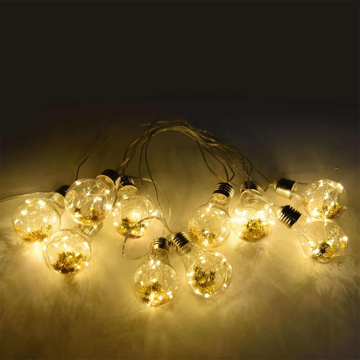 Eine Lichterkette mit klaren, runden Lichtern und gelben Innendekorationen, beleuchtet.