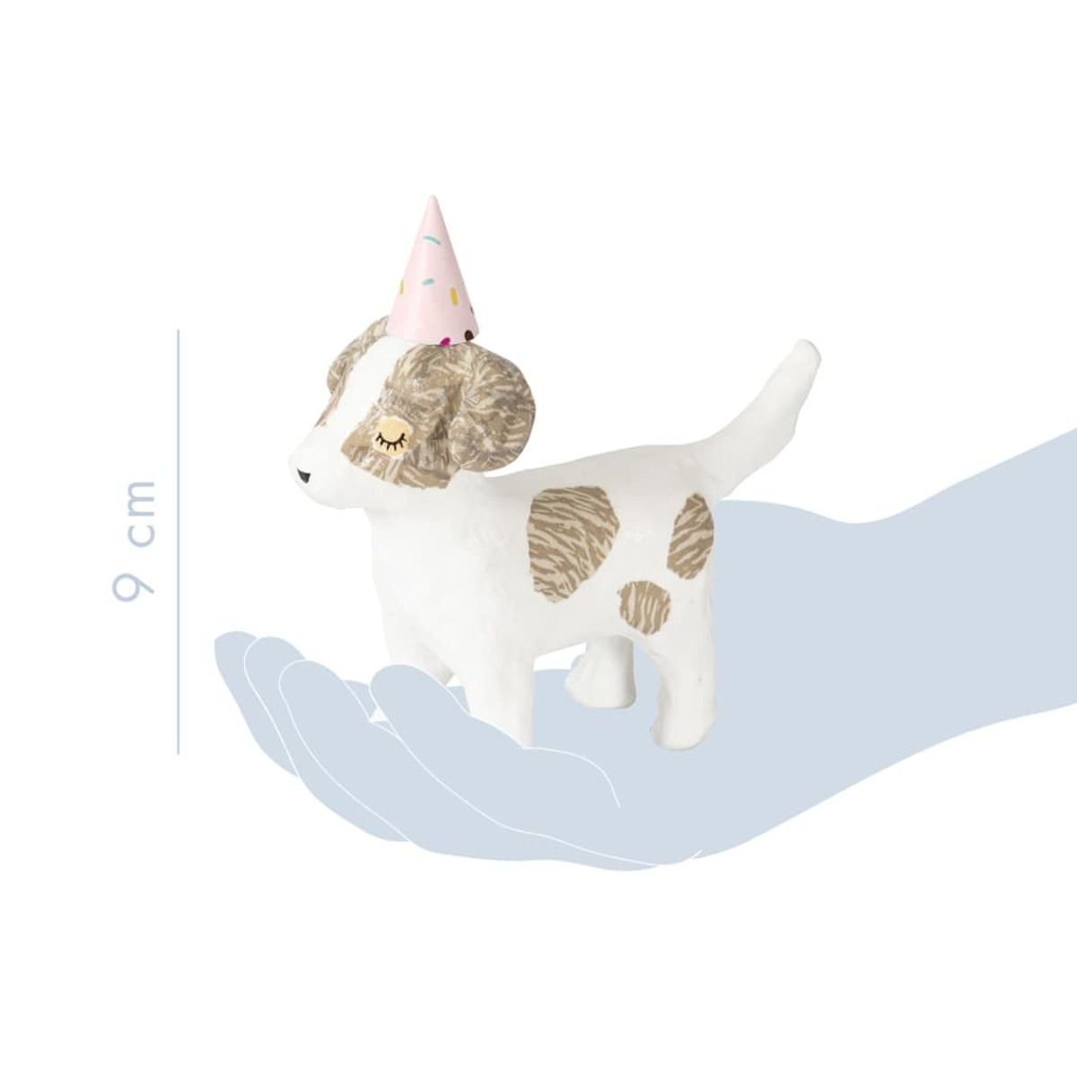 Eine weiße Hundefigur mit rosa Partyhut, gehalten in einer Hand.