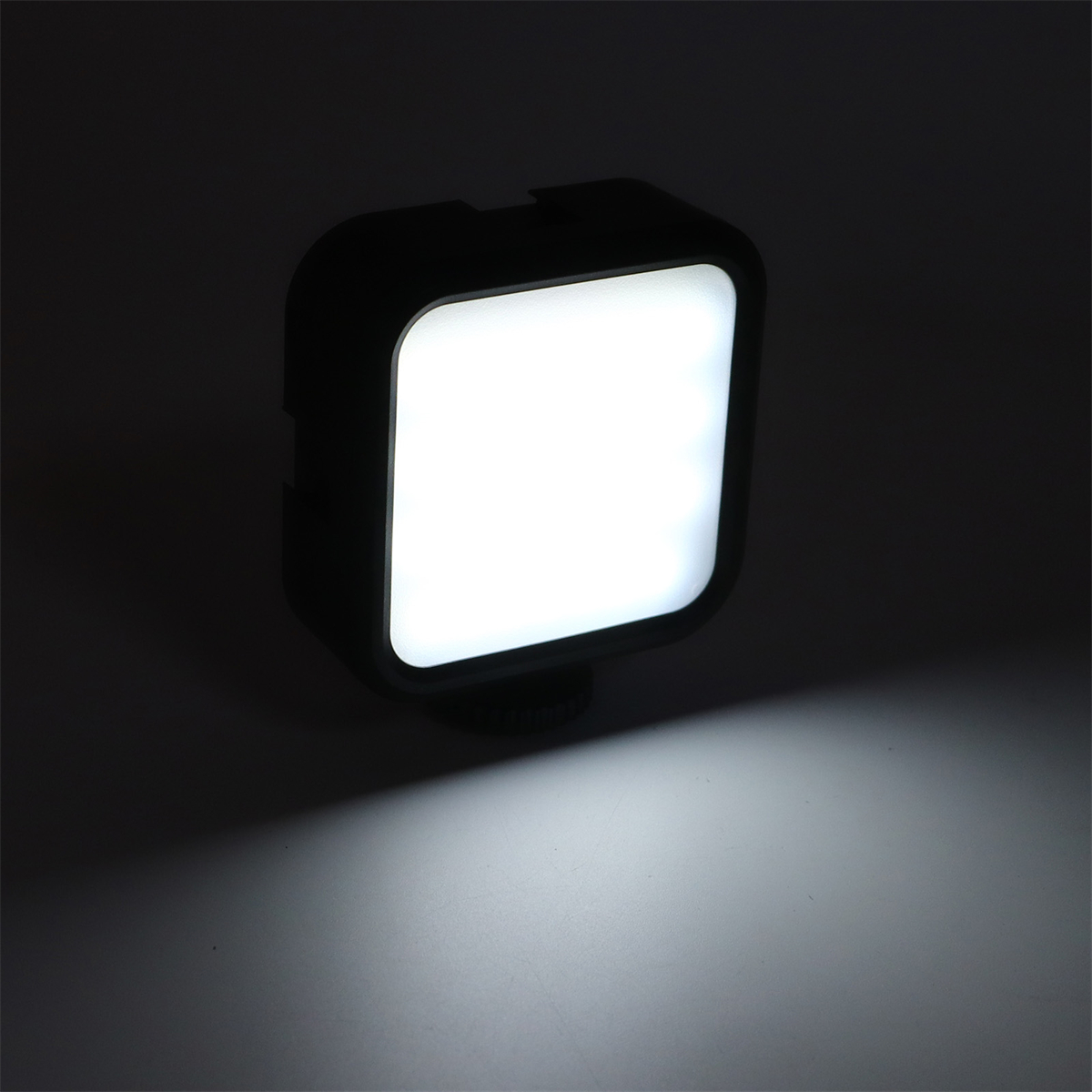 Ein quadratisches LED-Licht, das ein starkes weißes Licht aussendet, vor einem dunklen Hintergrund. Das Licht ist schwarz.