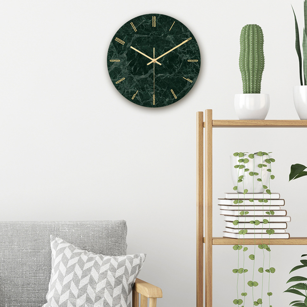 Eine dunkelgrüne Uhr mit Marmormuster und goldenen Zeigern, neben einem Kaktus und Pflanzen.