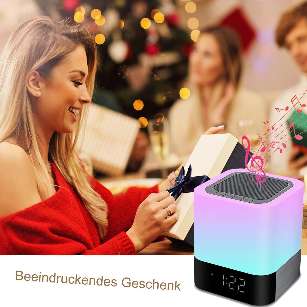 Eine Frau öffnet eine Geschenkbox in der Nähe eines Lautsprechers mit bunten Lichtern und Noten.