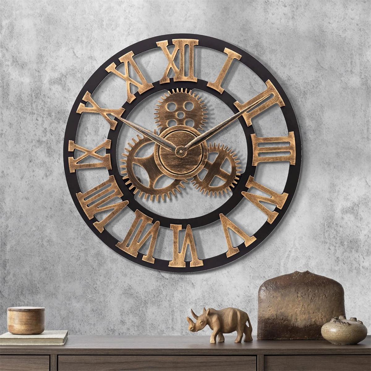 Große Wanduhr mit römischen Ziffern und Zahnrädern. Braun-Schwarz-Farbschema, an einer grauen Wand.