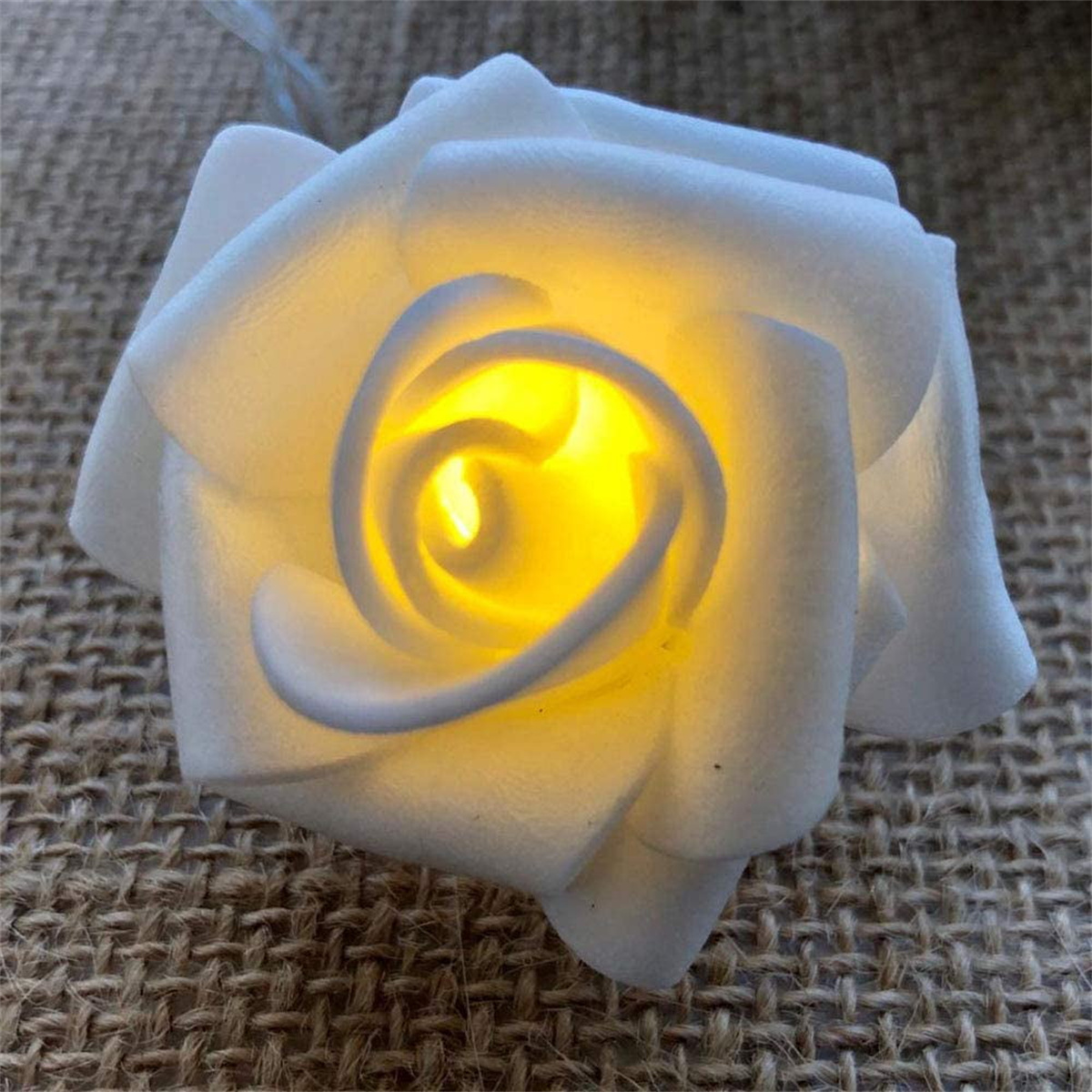 Ein weißes rosenförmiges Licht mit gelbem Zentrum auf strukturiertem Hintergrund.