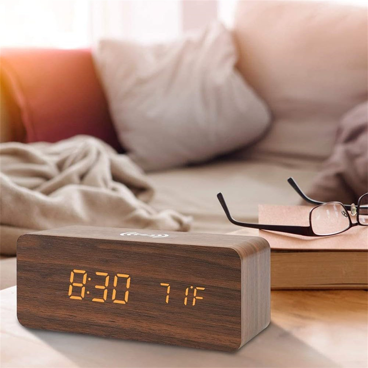 Ein hölzerner Wecker zeigt 8:30 und 71F. Eine Brille liegt auf einem Buch.
