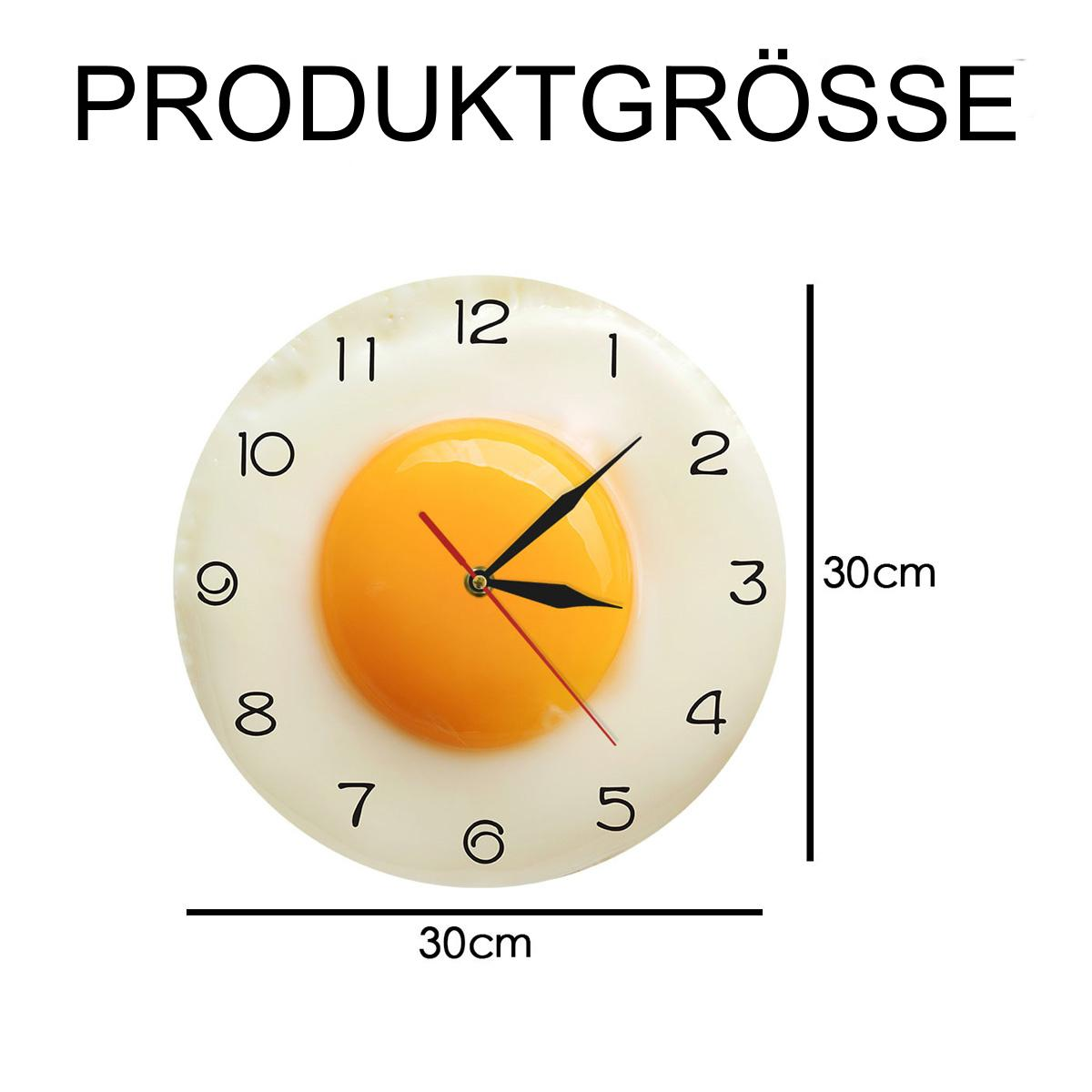 Eine Uhr, die wie ein Spiegelei aussieht. Sie ist rund, 30 cm Durchmesser. Schwarze Zeiger und ein roter Sekundenzeiger.