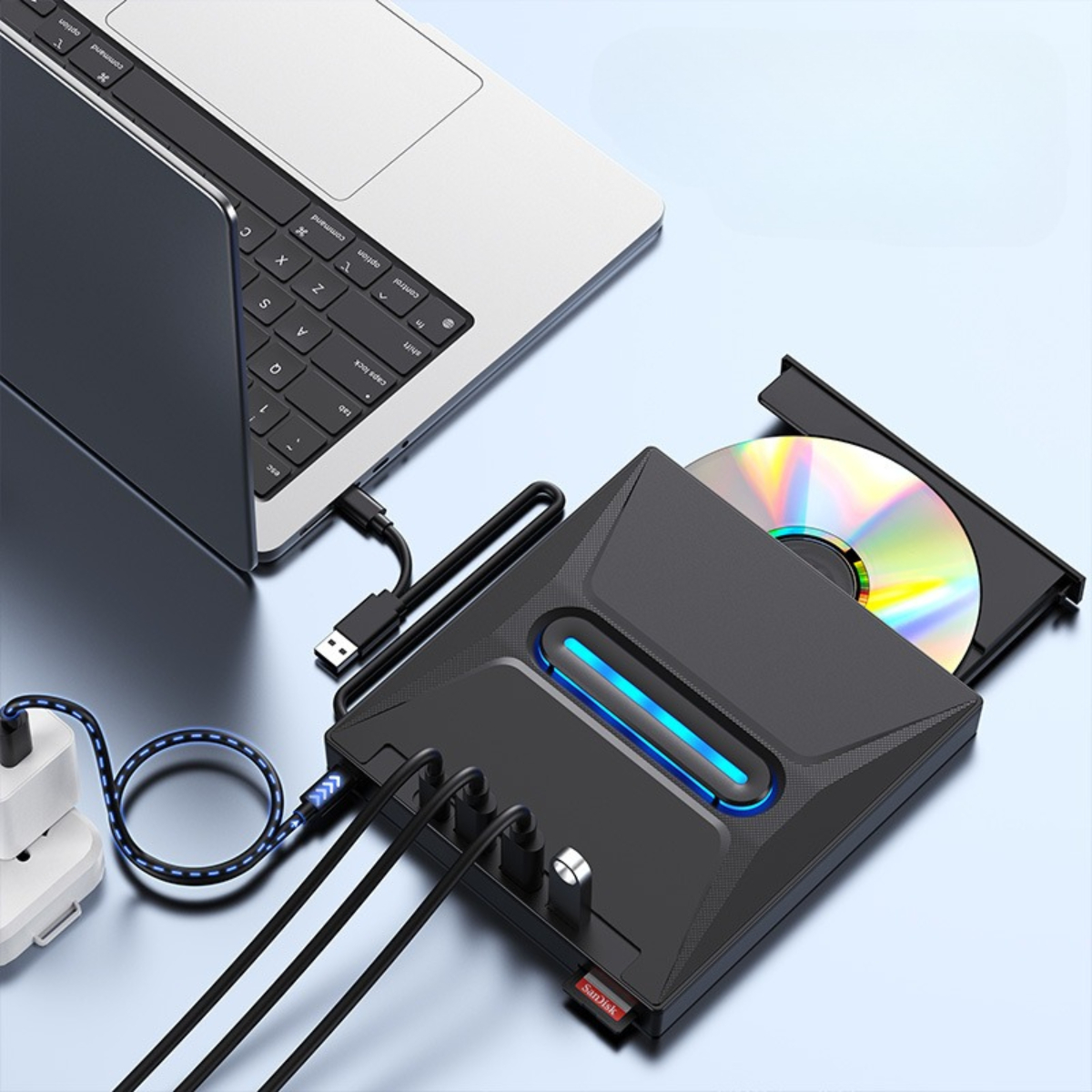 Ein schwarzes Gerät mit CD/DVD-Laufwerk, das an einen Laptop angeschlossen ist. USB- und Netzkabel sind angeschlossen.