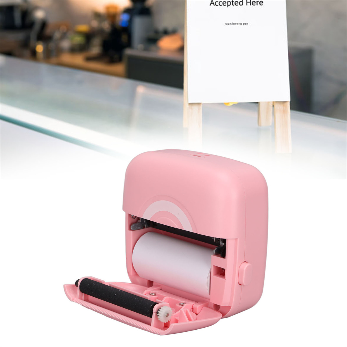 Rosa Thermodrucker mit offenem Deckel und Papierrolle, mit einem Schild 'Accepted Here'.