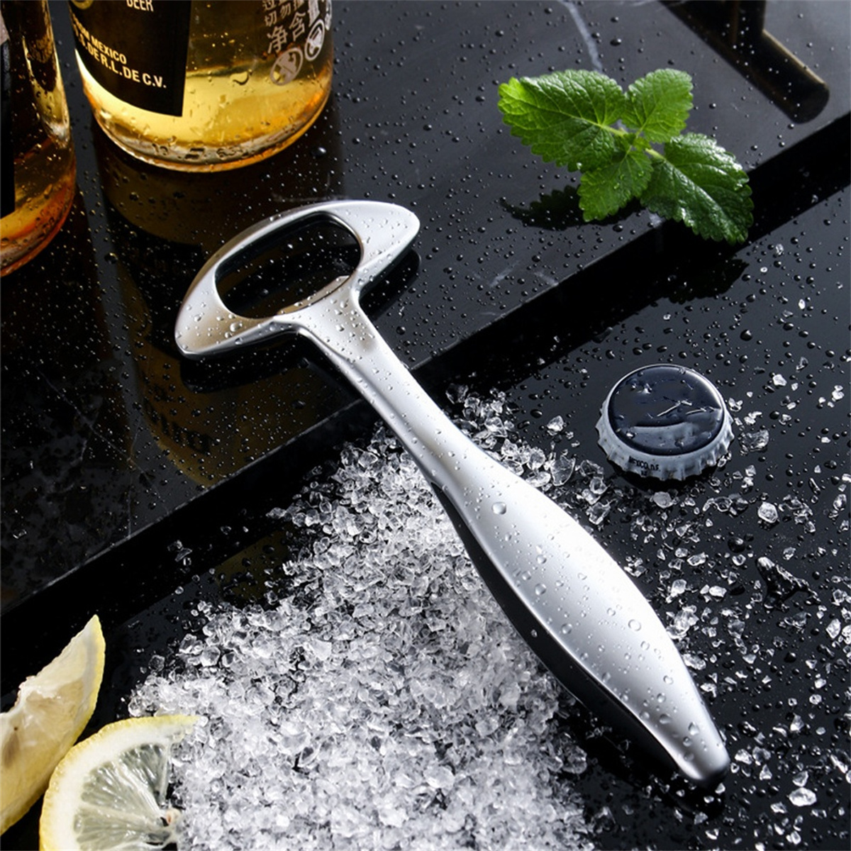 Silberner Flaschenöffner auf schwarzer Oberfläche mit Eis, einer Bierflasche, einem Kronkorken und Zitronenscheiben.