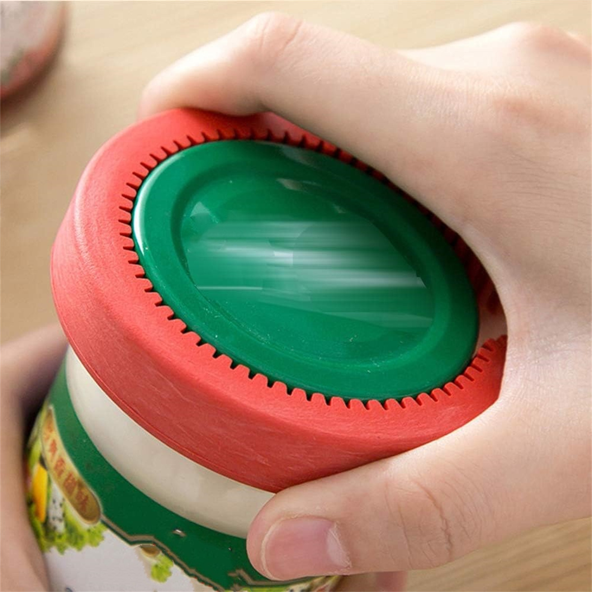 Eine Hand, die einen Deckelöffner hält, rot und grün in der Farbe.