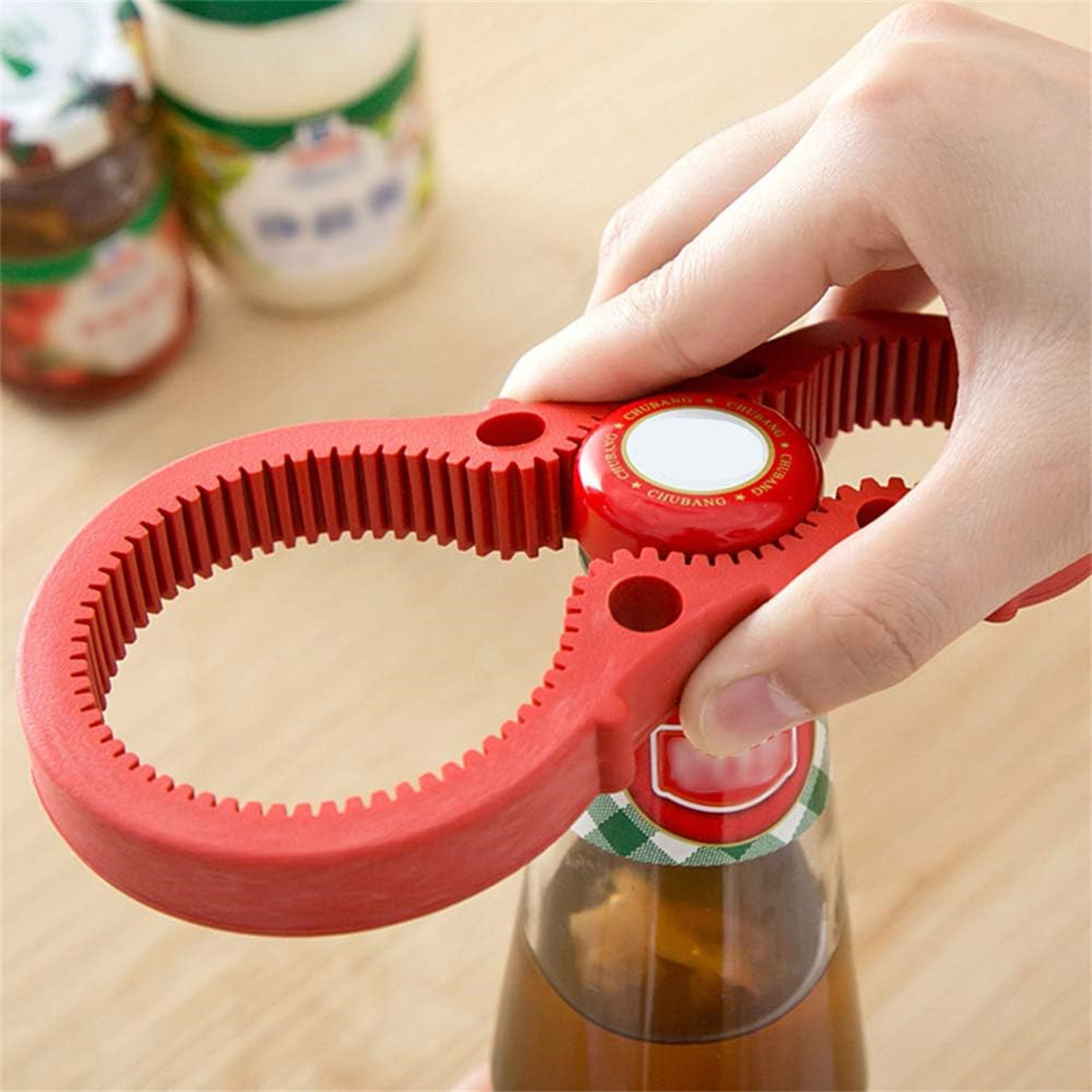 Ein roter Gläseröffner wird über einem Glas gehalten, um es zu öffnen.
