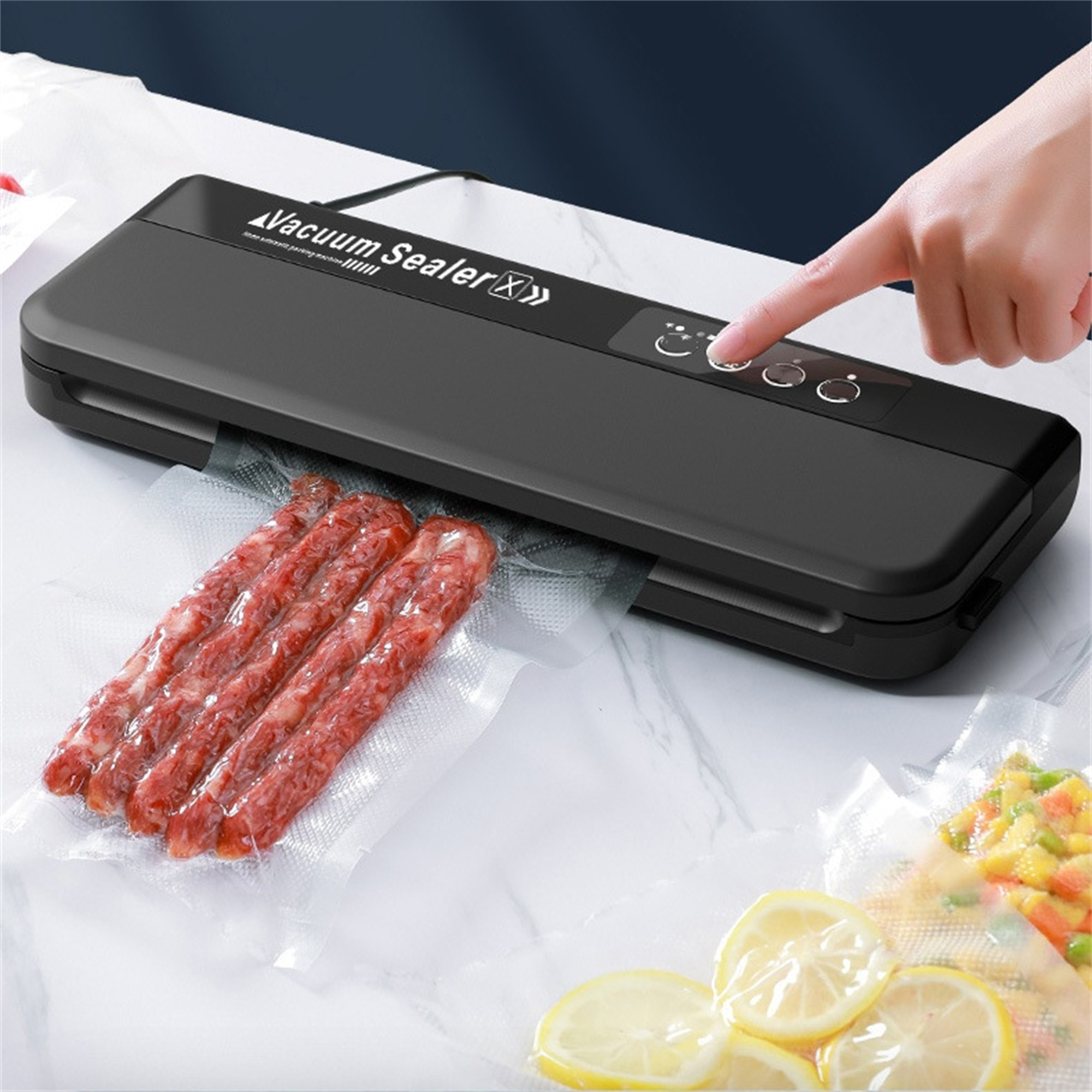 Schwarzes Vakuumiergerät mit Würstchen und Gemüse, eine Hand drückt den Knopf.