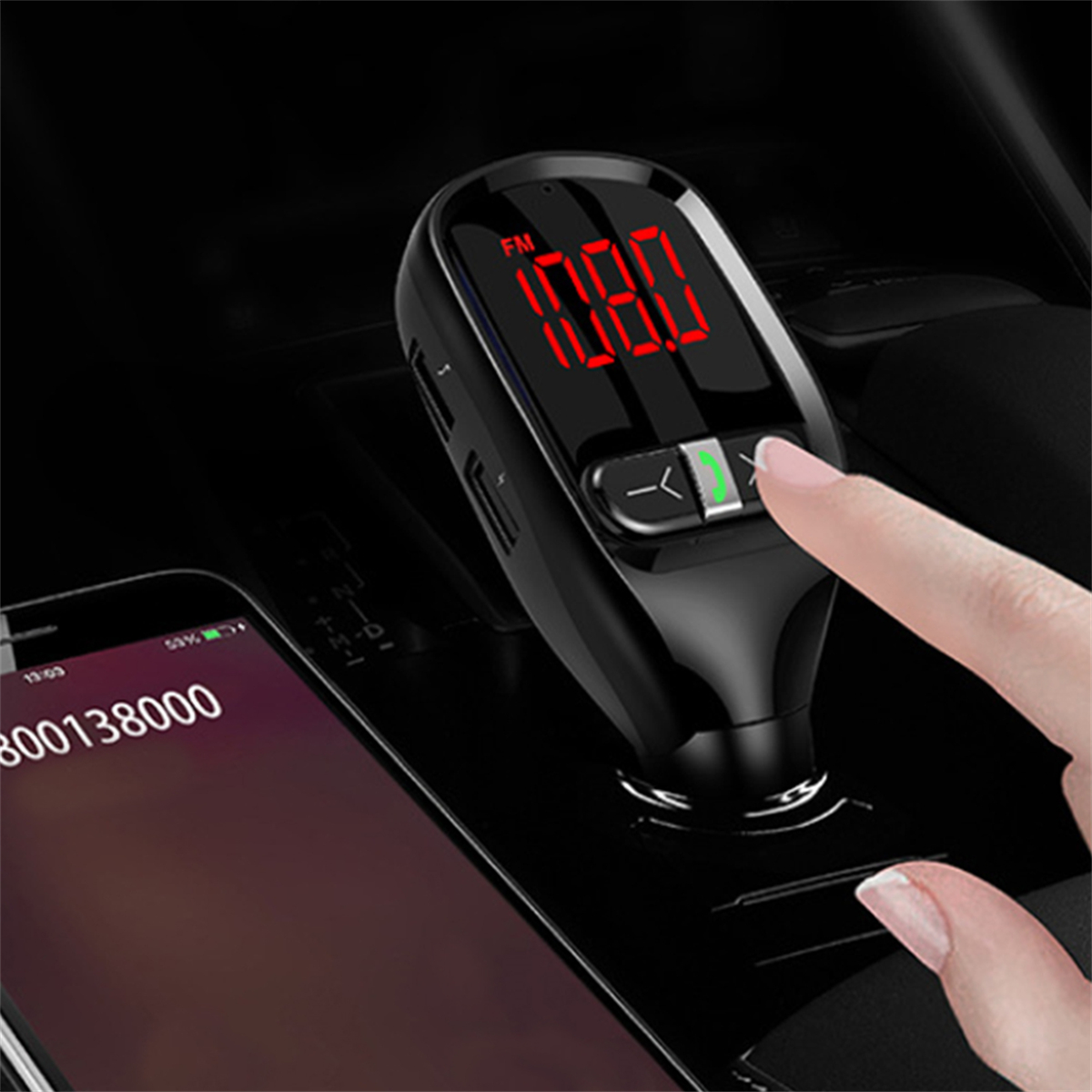 Schwarzer FM-Transmitter für das Auto mit Digitalanzeige, die die Frequenz anzeigt. Eine Hand berührt das Gerät.