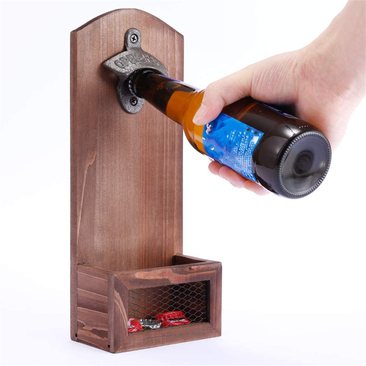 Hand öffnet Bierflasche mit hölzerner Wandhalterung. Rote Kronkorken in einem Fach.