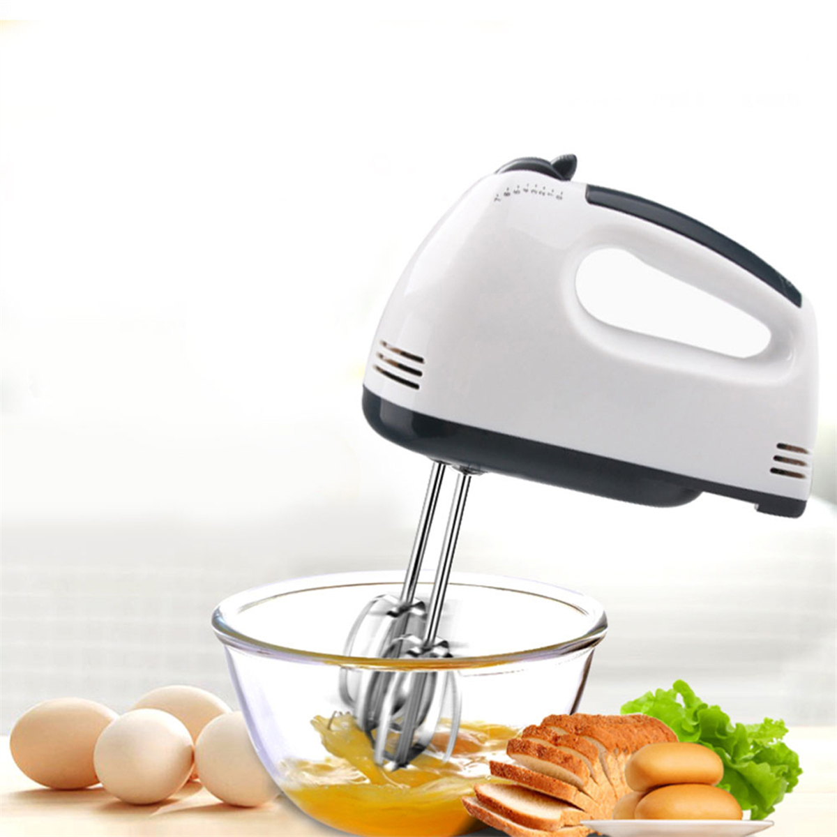 Ein elektrischer Mixer steht über einer Schüssel mit geschlagenen Eiern, mit Brot und Eiern daneben.