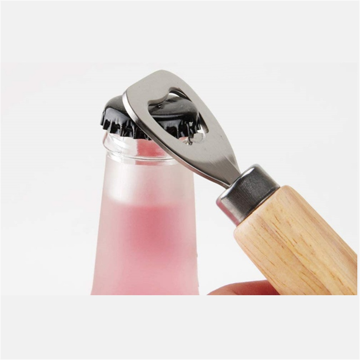 Ein Flaschenöffner, der eine Kappe von einer rosa Flasche entfernt.