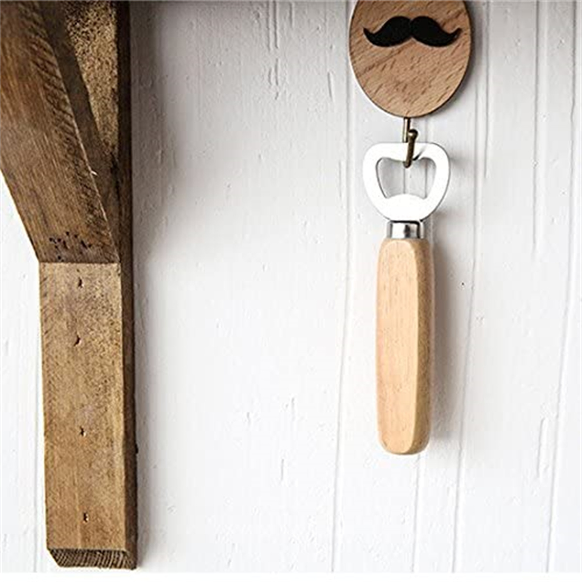 Flaschenöffner aus Holz mit Schnurrbart-Design, an weißer Wand hängend.