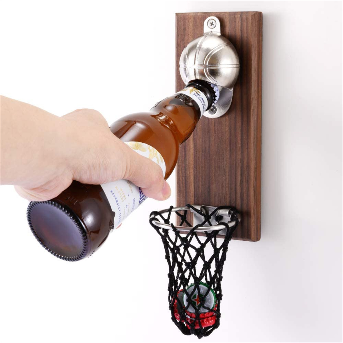 Eine Person öffnet eine Bierflasche in einen Basketballkorb.