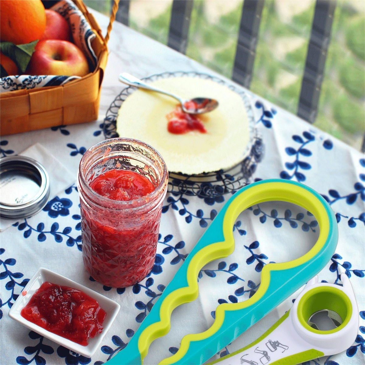 Tisch mit Marmelade, Glas, Löffel und Kuchen mit Obst in einem Korb.